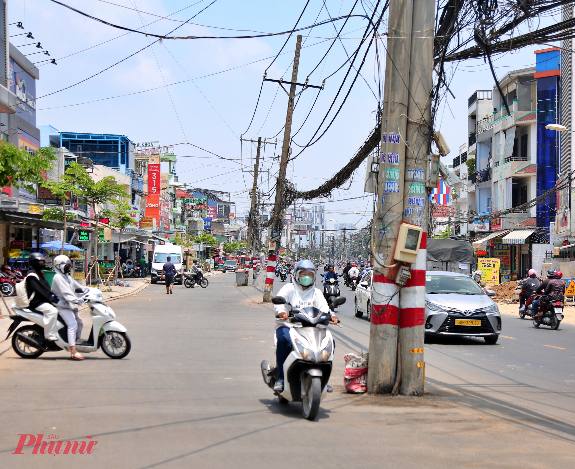 Xe máy luồn lách qua hàng trụ điện 