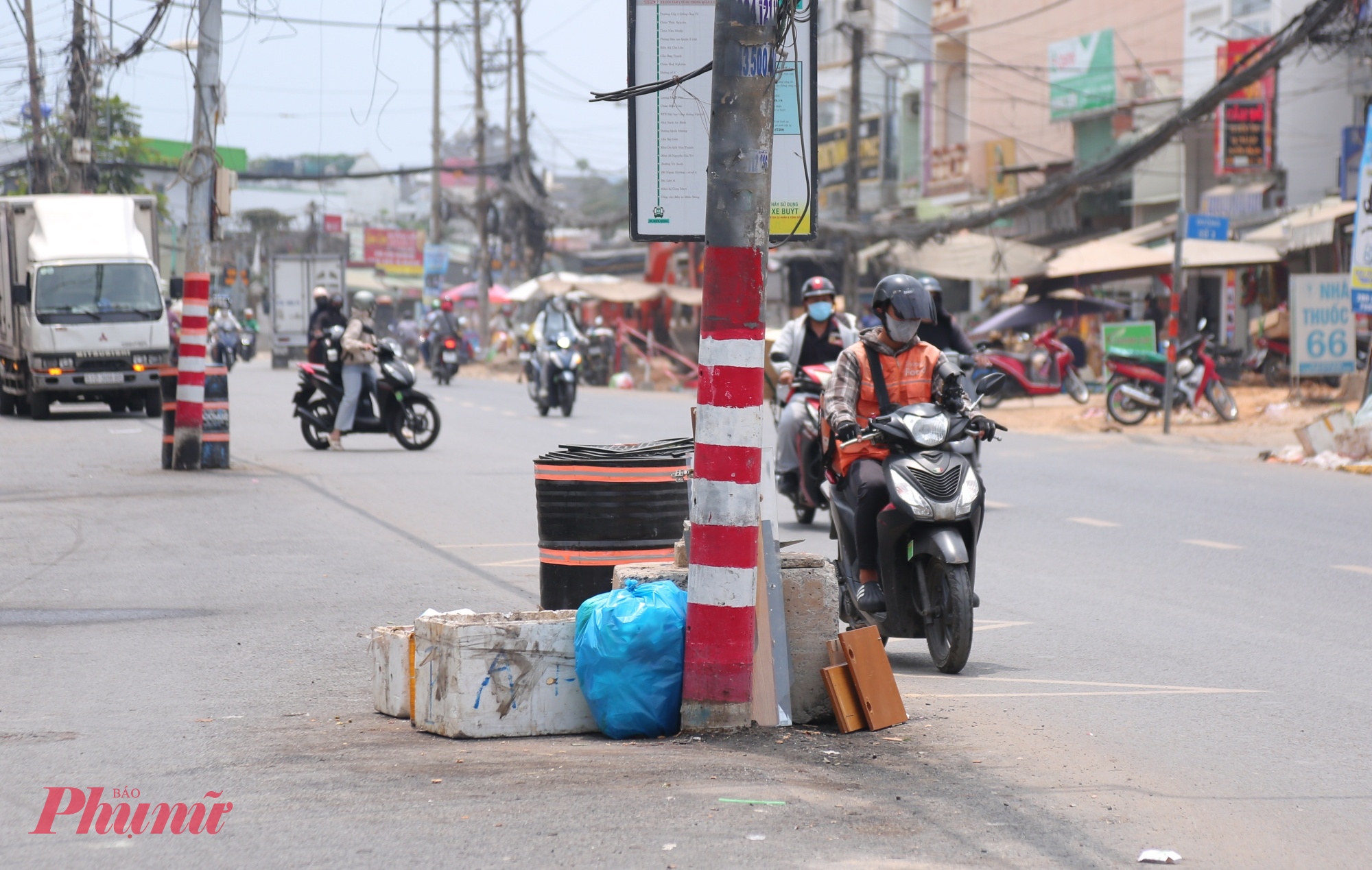Nhiều trụ điện dưới lòng đường trở thành nơi tập kết rác thải của người dân ven đường.