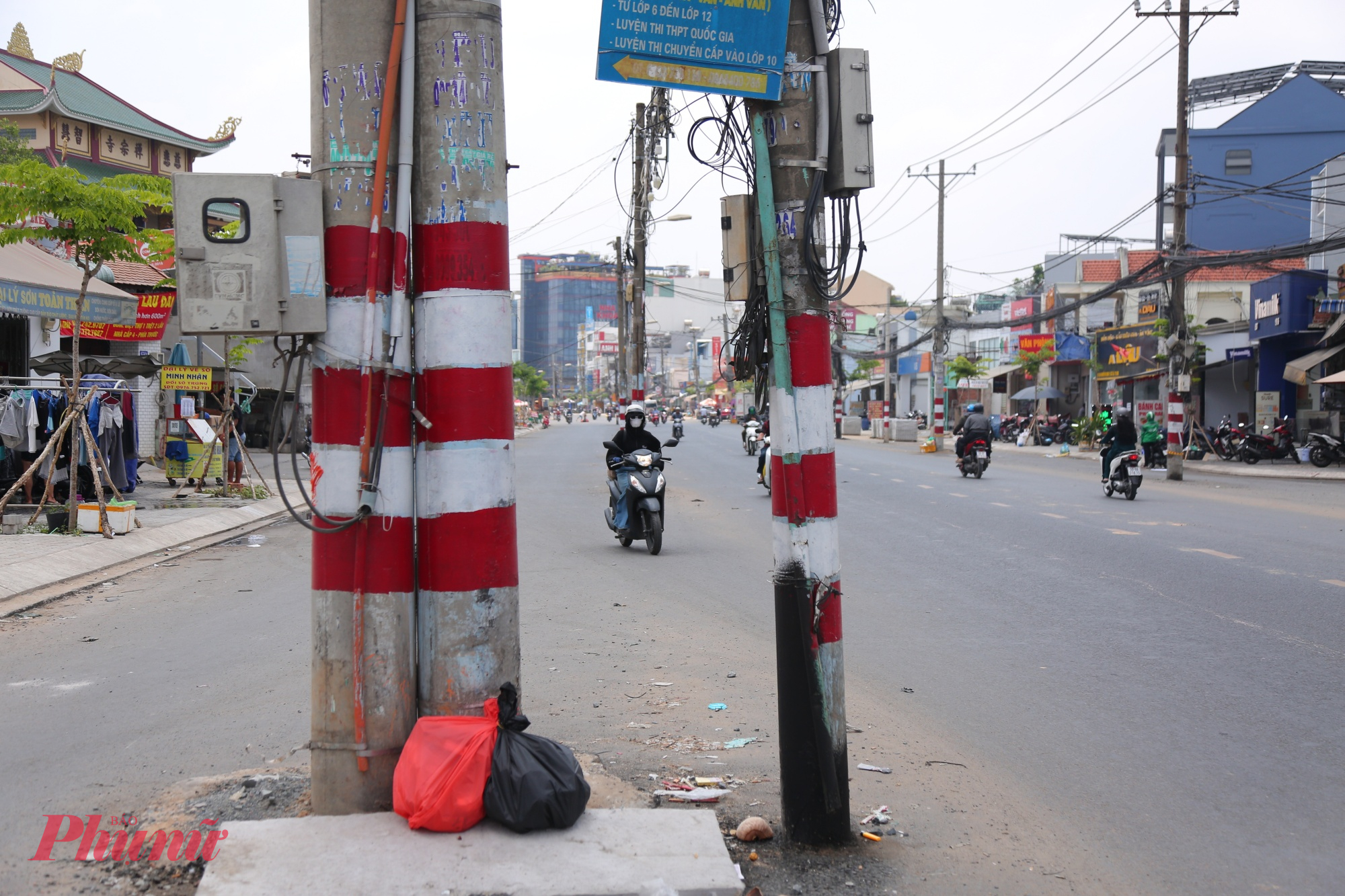 Người dân vừa chạy xe vừa lo tông trúng các trụ điện giữa đường.