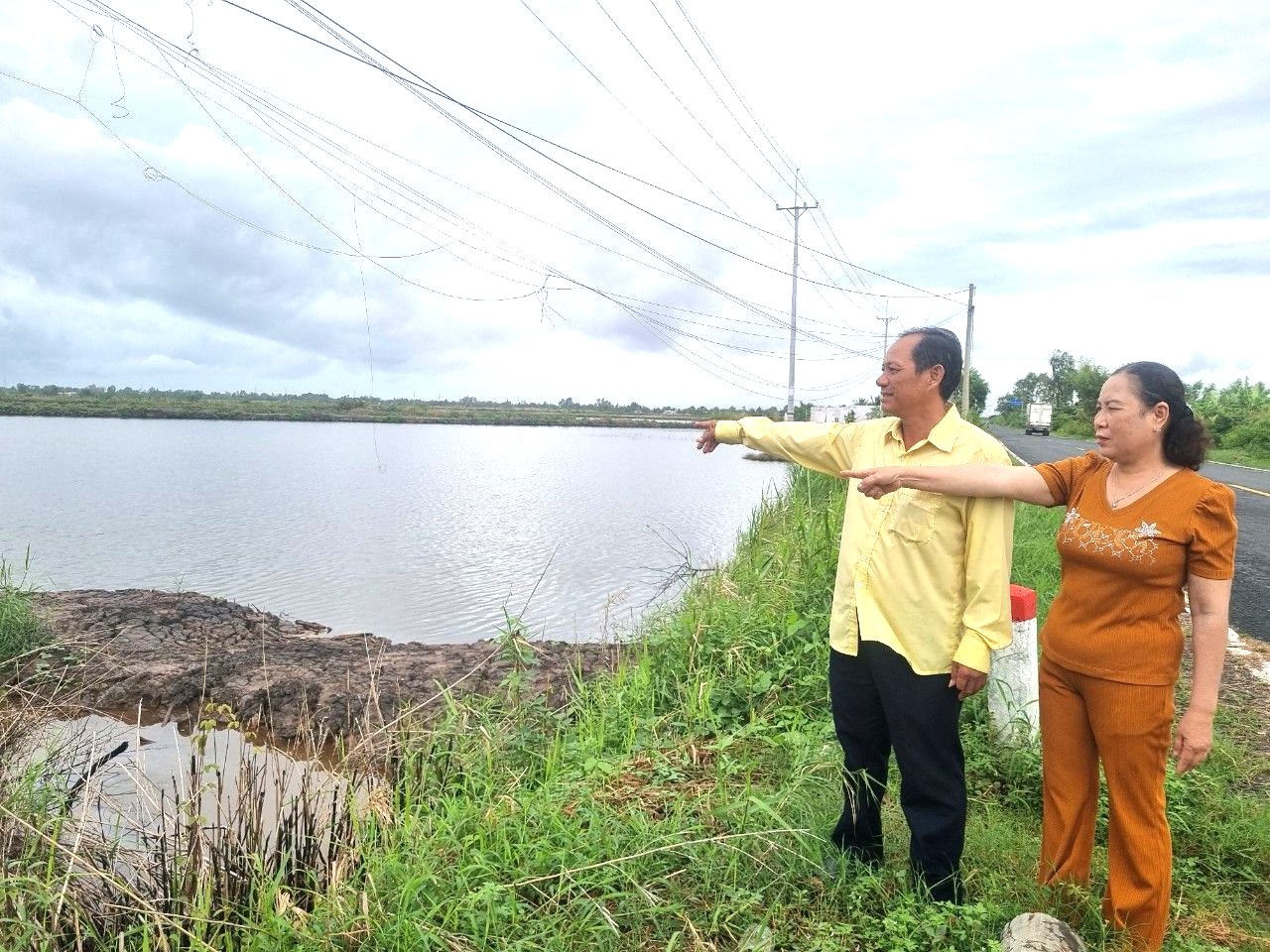 Vợ chồng ông Đấu bên phần đất bán cho bà Mai - nhưng chưa nhận đủ tiền. Ảnh: CTV