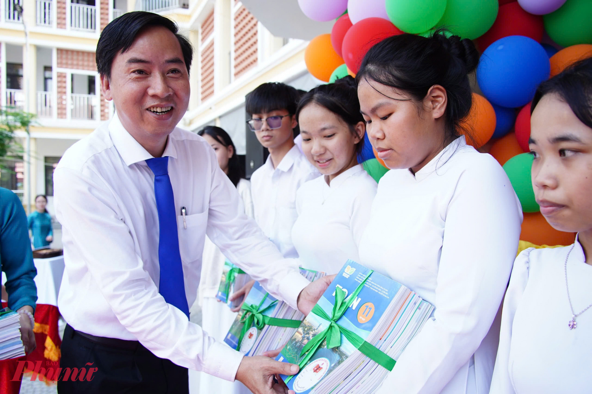 Ông Lê Phú Nguyện - Chủ tịch UBND xã Hoà Vang - trao sách giáo khoa cho các em học sinh.