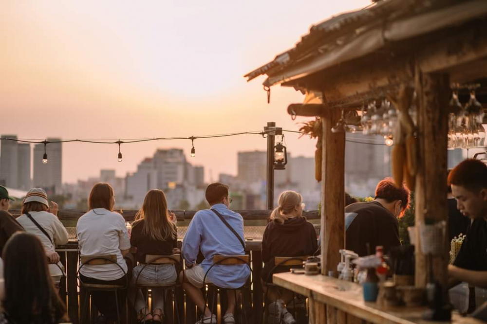 Chênh Vênh Rooftop (7 Đường số 54, phường An Khánh) sở hữu view Landmark 81, có thể nhìn thấy sông Sài Gòn thơ mộng, cùng lối trang trí mang phong cách hoài cổ với nội thất hoàn toàn bằng gỗ thông. Ngoài việc ngắm được hoàng hôn thơ mộng, mỗi tối thứ 7 hàng tuần quán sẽ có chương trình Live Acoustic vào lúc 19:30 – 21:30, thích hợp cho những ngày bạn cần được thư giãn.