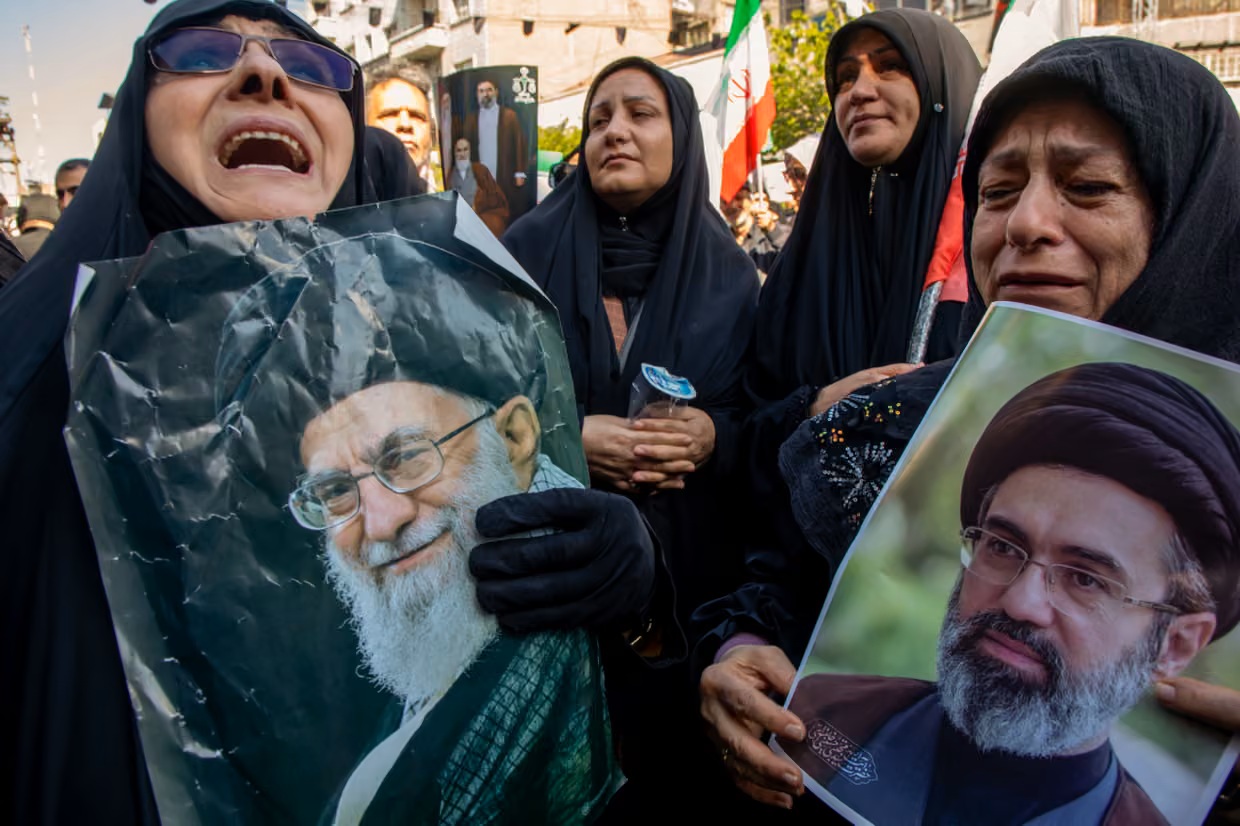 Những người phụ nữ cầm chân dung của cố lãnh đạo tối cao Iran, Ali Khamenei (trái) và con trai ông, Mojtaba Khamenei. Polymarket tổ chức các cuộc cá cược về việc liệu ông Mojtaba có kế vị cha mình hay không - Ảnh: Majid Saeedi/Getty Images