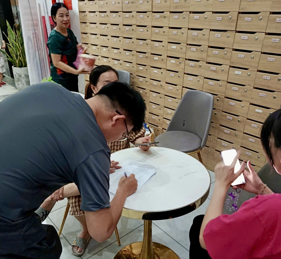 Cư dân Bcons Garden tiếp tục lấy chữ ký của các hộ dân phản hồi đến ban quan trị quanh quỹ bảo trì hồi 12/4 tại sảnh chung cư. Ảnh: Cư dân cung cấp.