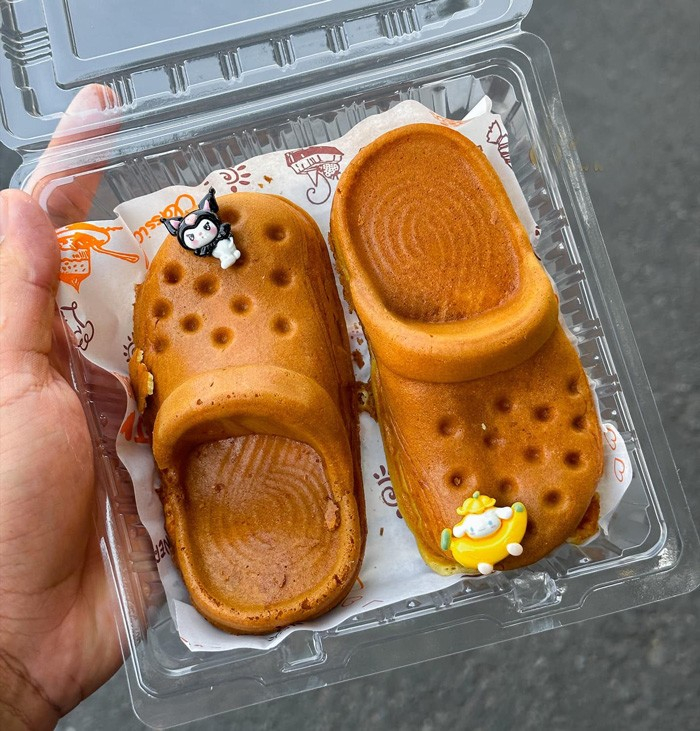 Gây ấn tượng ngay từ tên gọi, bánh mì dép phô mai thu hút bởi hình dáng dẹt dài, lạ mắt. Lớp vỏ bánh được nướng vàng giòn, bên trong là phần nhân phô mai dày, tan chảy khi còn nóng. Điểm khiến món này “viral” mạnh mẽ chính là hiệu ứng kéo sợi của phô mai – chỉ cần tách nhẹ, lớp nhân đã kéo dài hấp dẫn, cực kỳ “ăn hình”. Hương vị béo thơm, mặn nhẹ, dễ ăn khiến món này trở thành lựa chọn quen thuộc cho những buổi tụ tập bạn bè hoặc ăn vặt cuối ngày.