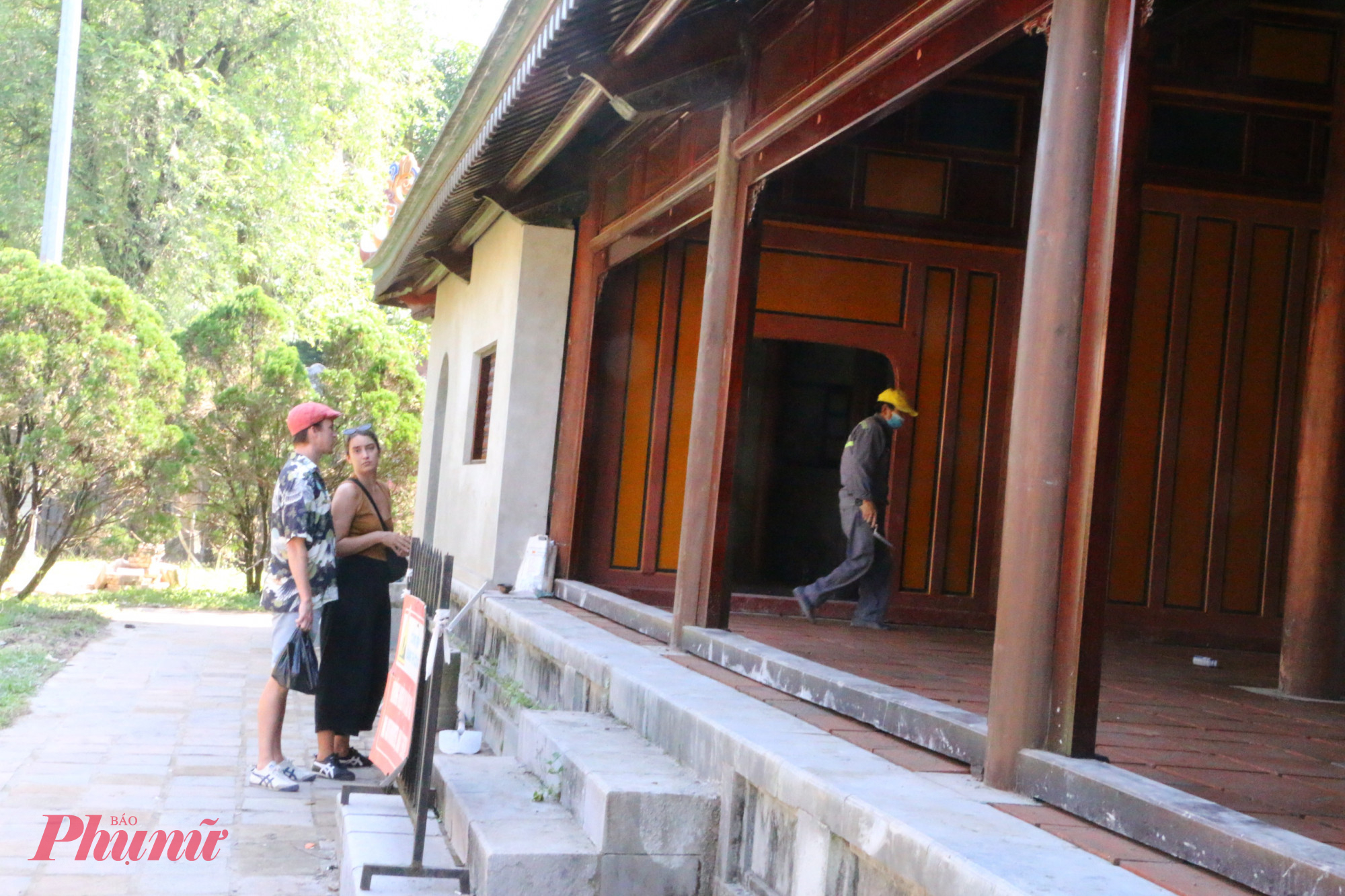 Du khách xem những người thợ trùng tu Minh Khiêm đường ở lăng vua Tự Đức