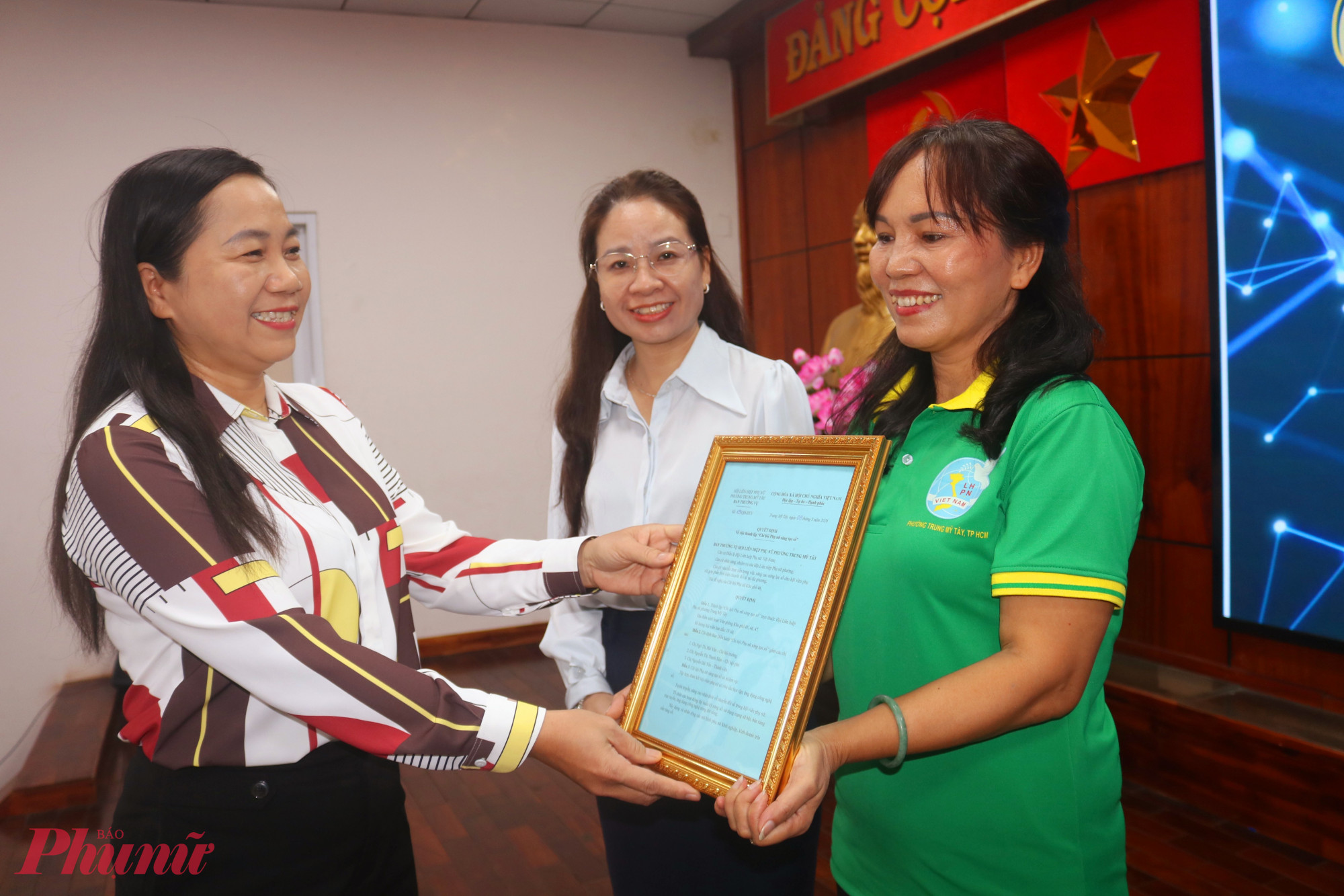 Bà Nguyễn Thị Kim Cúc – Chủ tịch Ủy ban MTTQ Việt Nam phường Trung Mỹ Tây – trao quyết định của Hội LHPN phường về việc thành lập Chi hội Phụ nữ Sáng tạo số đến các chị trong ban điều hành chi hội - Ảnh: Mẫn Nhi