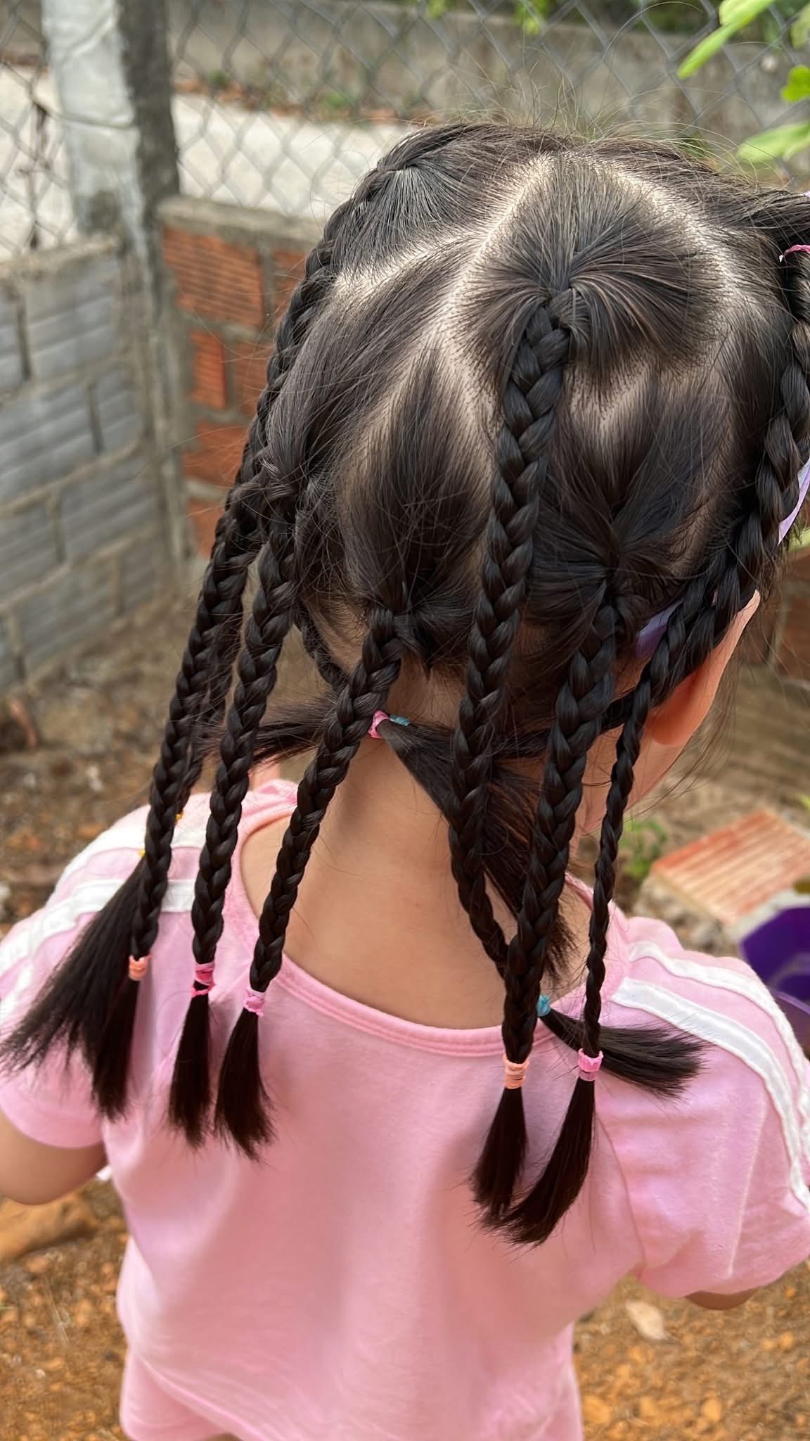 Những bím tóc nhỏ, tết đều từ chân tóc xuống được 'nâng cấp' hơn nhờ phần đuôi được thắt vào nhau. Các mẹ muốn làm kiểu tóc này cho bé thì hãy chia tóc thành nhiều lọn nhỏ, tết từng lọn rồi buộc lại. Thành quả là mái tóc gọn gàng, bền vững qua mọi hoạt động chạy nhảy suốt cả ngày. Đây có lẽ là kiểu được phụ huynh 'ưng bụng' nhất vì vừa đẹp vừa ít phải chỉnh lại.