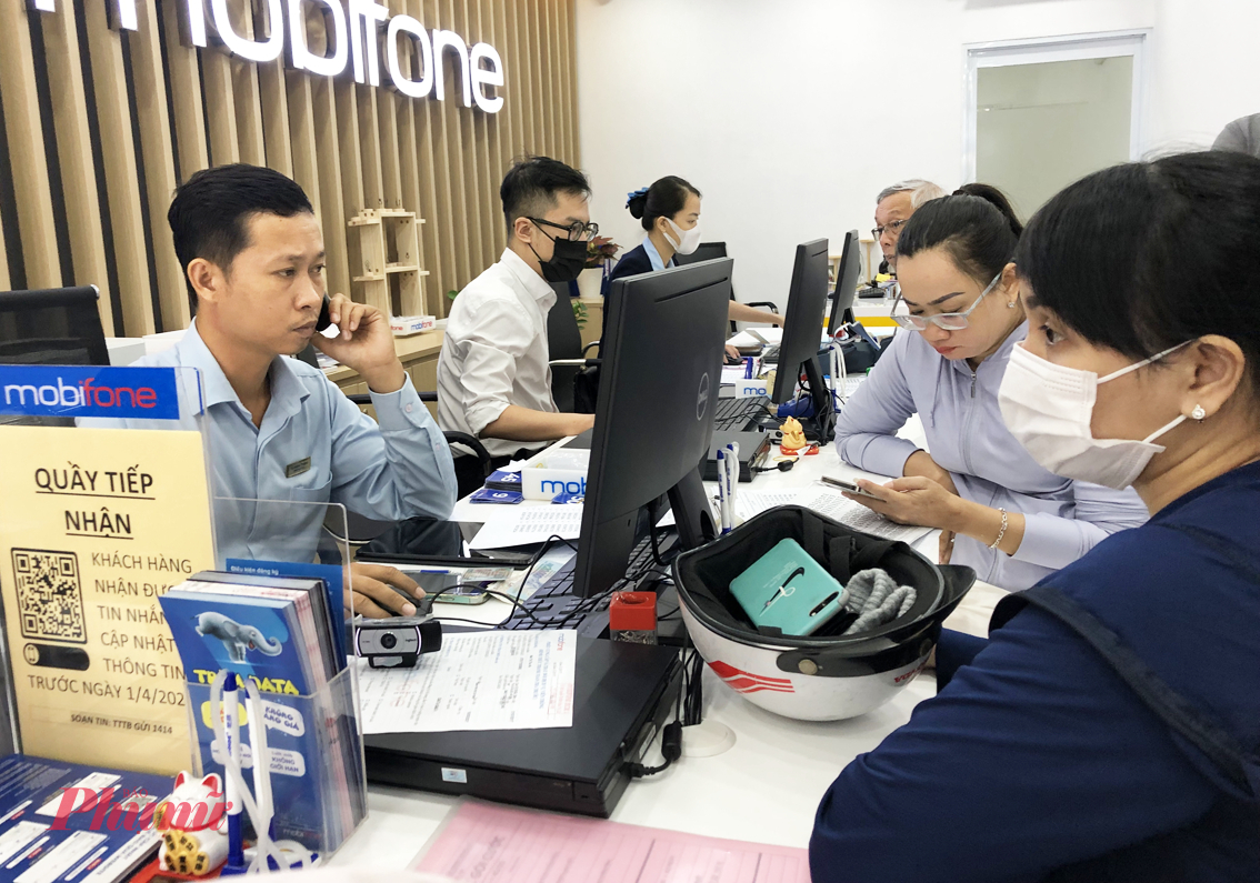 Khách hàng làm thủ tục đăng ký thuê bao ở cửa hàng MobiFone trên đường Nguyễn Thị Minh Khai, TPHCM - Ảnh: Thanh Hoa