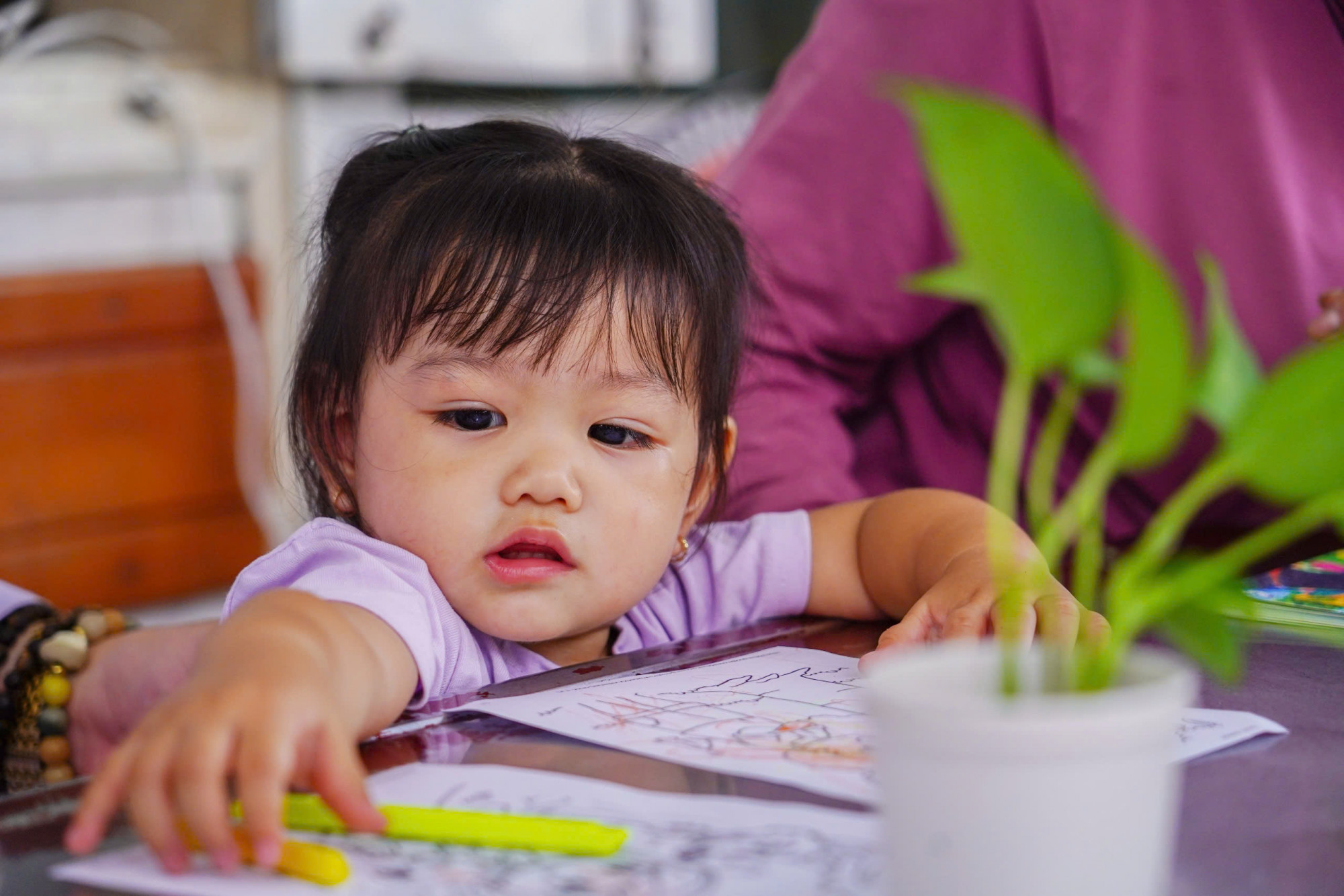 Sau khi chọn được quyển tô màu yêu thích, bé gái liền cầm màu vẽ để tô cho nhân vật trong sách