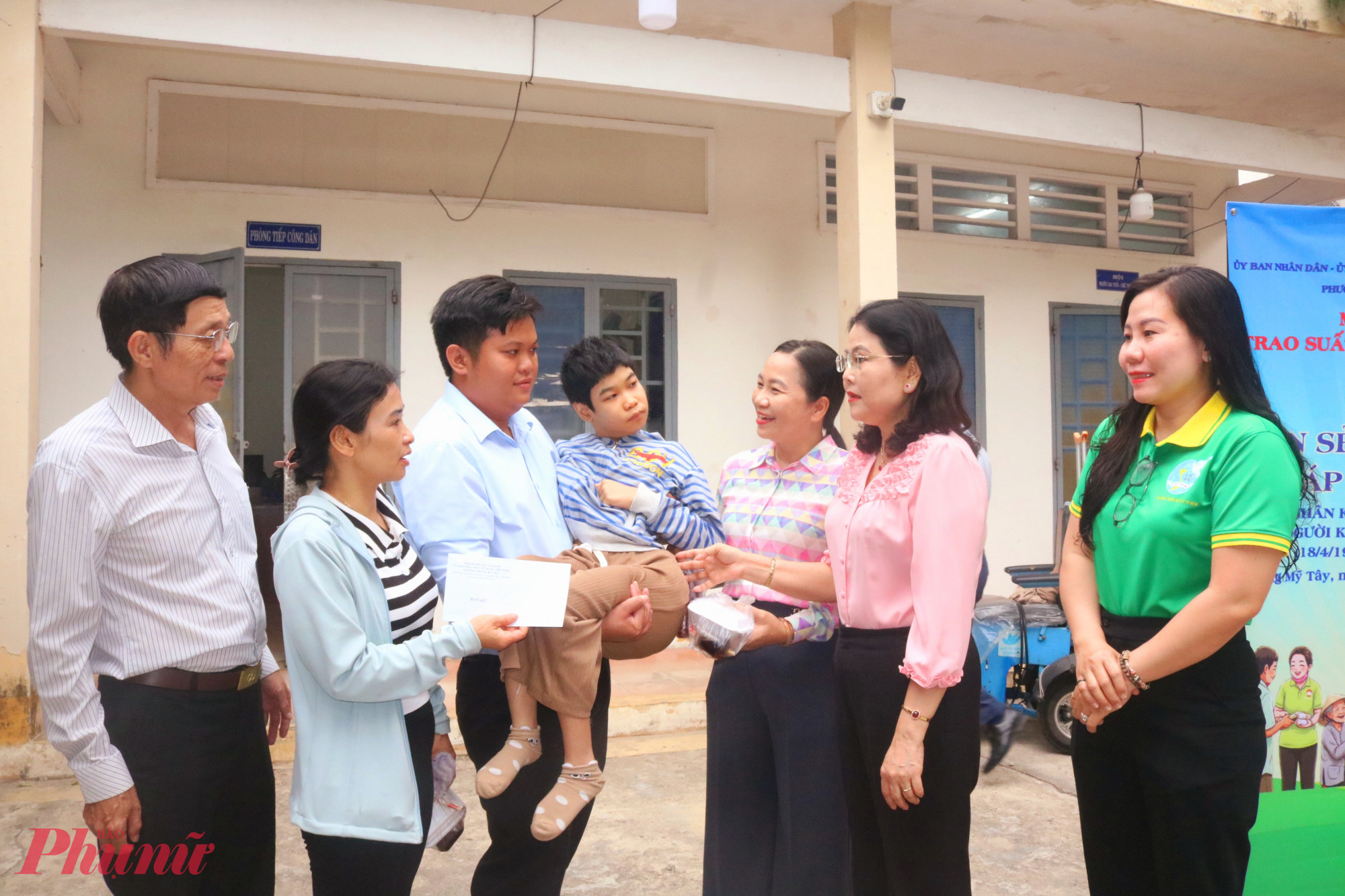 Bà Nguyễn Thị Ngọc Duyên – Bí thư Đảng ủy, Chủ tịch HĐND phường Trung Mỹ Tây (thứ 2, từ trái qua) và bà Nguyễn Thị Kim Cúc – Chủ tịch Ủy ban MTTQ Việt Nam phường Trung Mỹ Tây (thứ 3, từ trái qua) – cùng đại diện các tổ chức chính trị - xã hội phường trao quà, trò chuyện động viên mẹ con em Phạm Thảo Vy. Vy sinh năm 2009, mắc bệnh về não, không có khả năng vận động. Mẹ em là chị Trần Thị Thanh (thứ 2, từ phải qua) đang làm tạp vụ - Ảnh: Mẫn Nhi