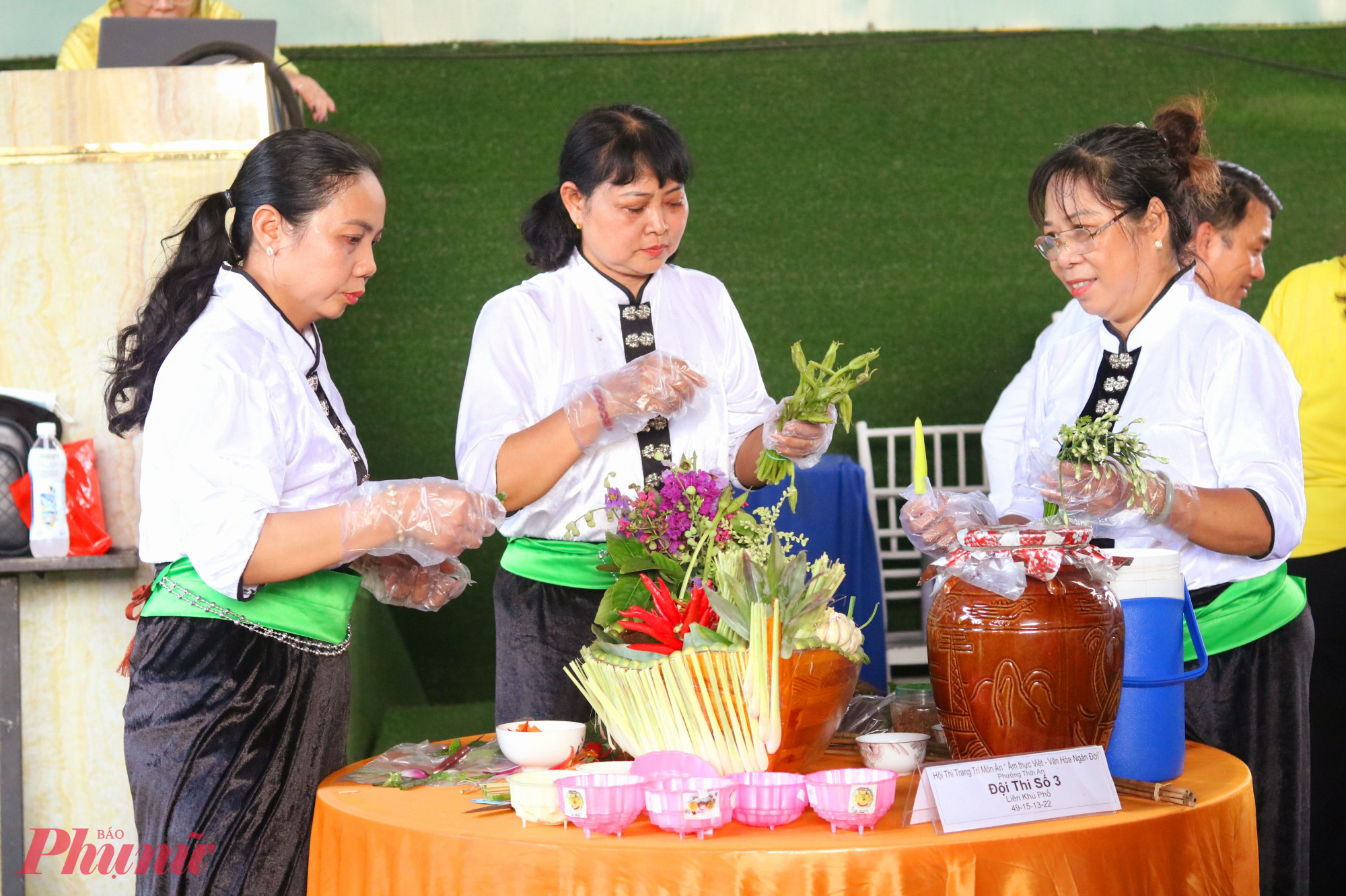 Các thành viên đội thi liên khu phố 49, 15, 13, 22 trang trí các món ăn mang hương sắc Tây Bắc là xôi ngũ sắc, thịt trâu gác bếp, rượu cần. Đây là 1 trong 3 đội thi đoạt giải ba chung cuộc - Ảnh: Mẫn Nhi