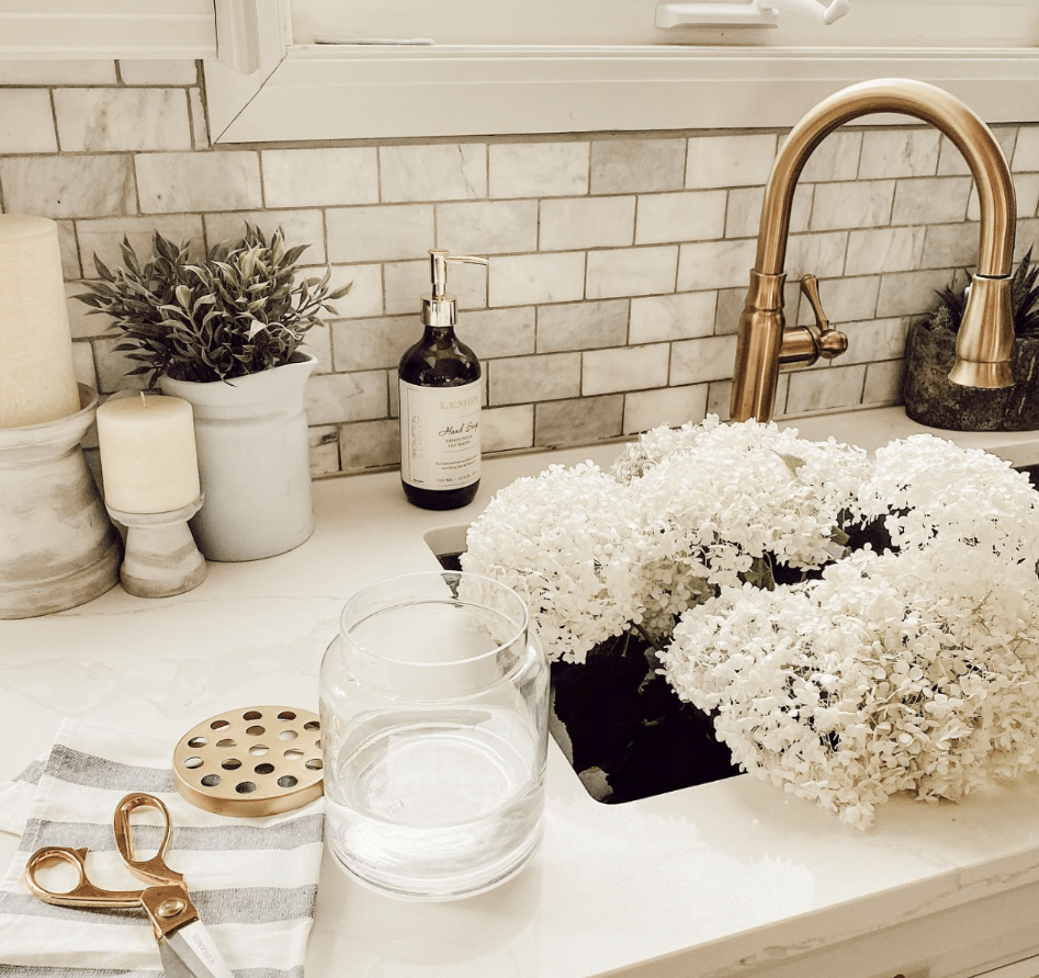 Trưng bày các loại hộp đựng độc đáo: Những hộp đựng độc đáo có thể tô điểm thêm cả phong cách và công năng cho quầy bếp của bạn. Hãy tìm những hộp đựng có hình dạng, màu sắc hoặc họa tiết thú vị, phù hợp với thiết kế nhà bếp. Sử dụng chúng để đựng những nguyên liệu thiết yếu như đường, bột mì, cà phê hoặc mì ống. Hũ thủy tinh có nắp đậy kín rất lý tưởng để trưng bày các nguyên liệu đầy màu sắc, trong khi hộp đựng bằng gốm hoặc kim loại có thể tạo thêm nét cổ điển hoặc công nghiệp. Hãy sắp xếp những hộp đựng này thành một hàng ngay ngắn hoặc nhóm chúng lại với nhau trên một khay trang trí để giữ cho mặt bàn bếp gọn gàng và đẹp mắt. Lợi ích bổ sung là bạn sẽ luôn có những nguyên liệu cần thiết trong tầm tay. Nguồn ảnh: @Holly Grace.