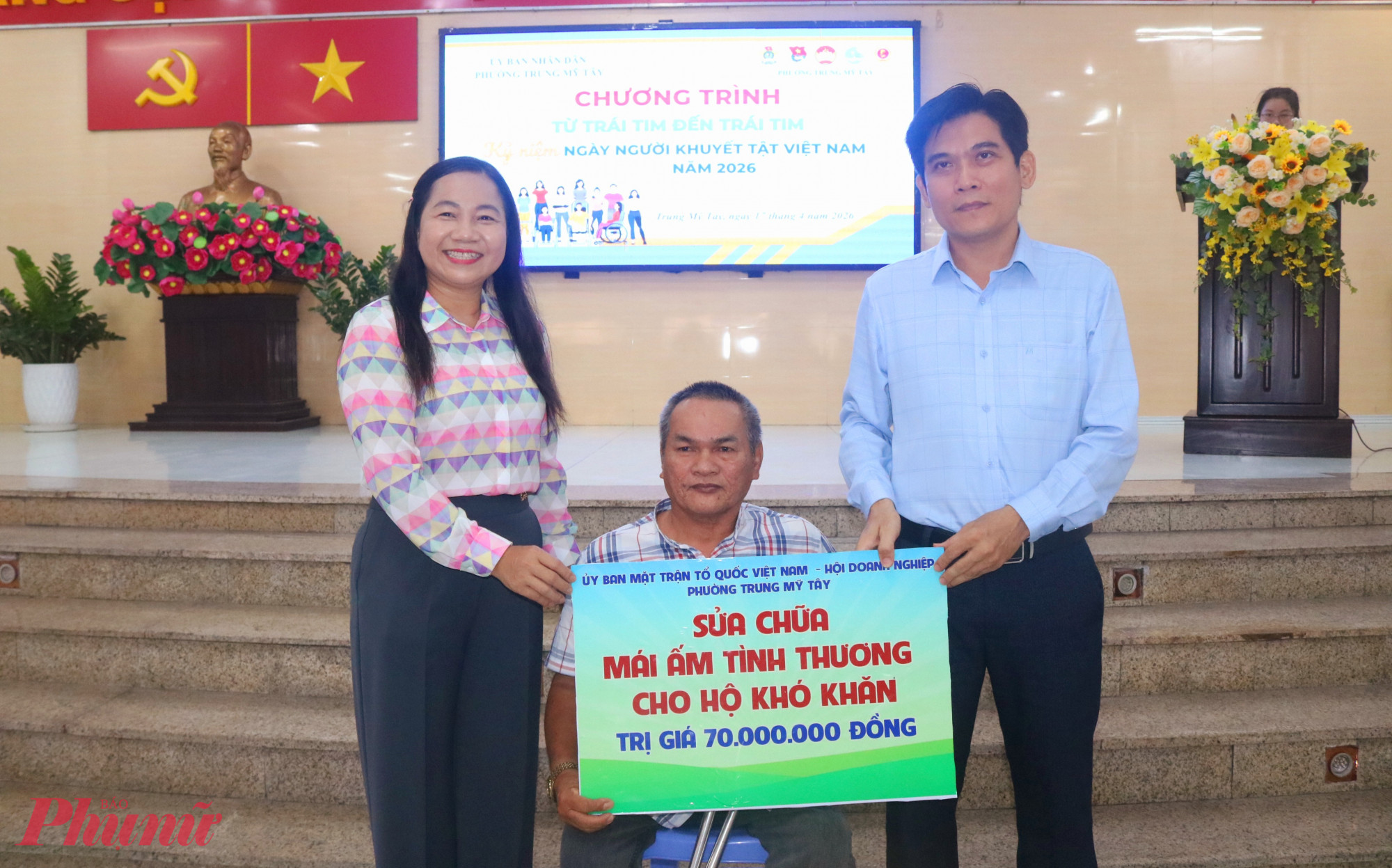 Ông Trần Kiều (giữa) nhận bảng tượng trưng về việc được hỗ trợ kinh phí sửa chữa nhà - Ảnh: Mẫn Nhi 