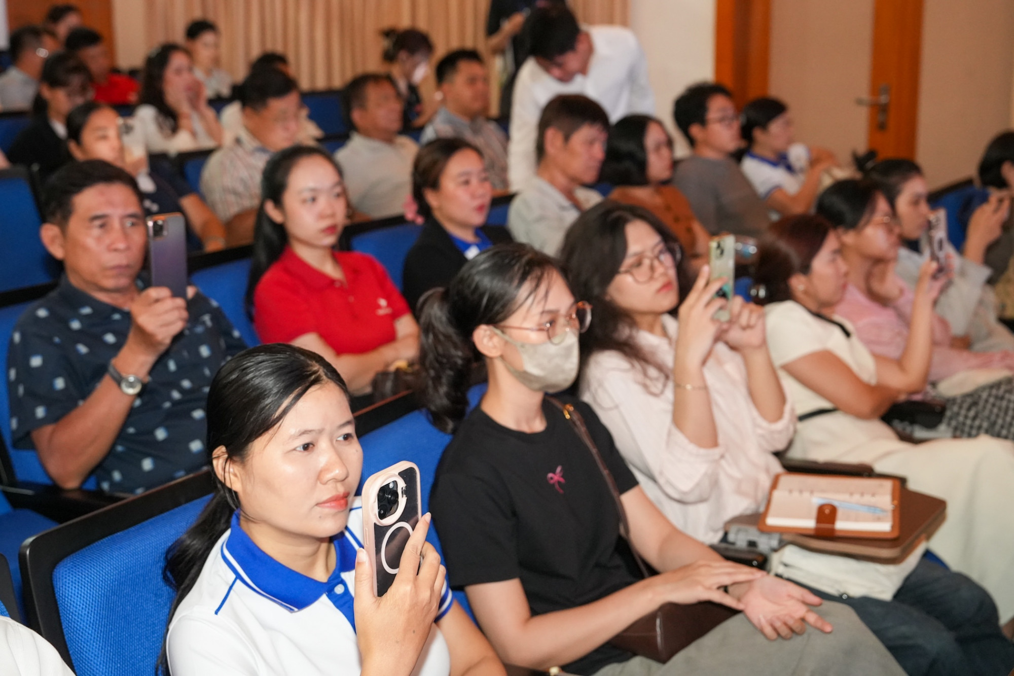 Các hộ kinh doanh ghi lại hướng dẫn thực hiện kê khai thuế trên màn hình - Ảnh: Hữu Thạnh