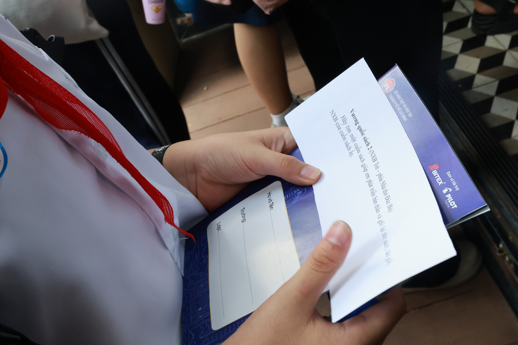 Em học sinh nhận “hộ chiếu” để đến các trạm “vương quốc sách” trải nghiệm