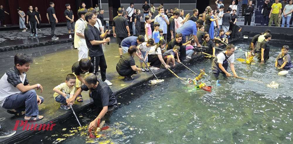 Các em nhỏ và phụ huynh trải nghiệm điều khiển rối nước.