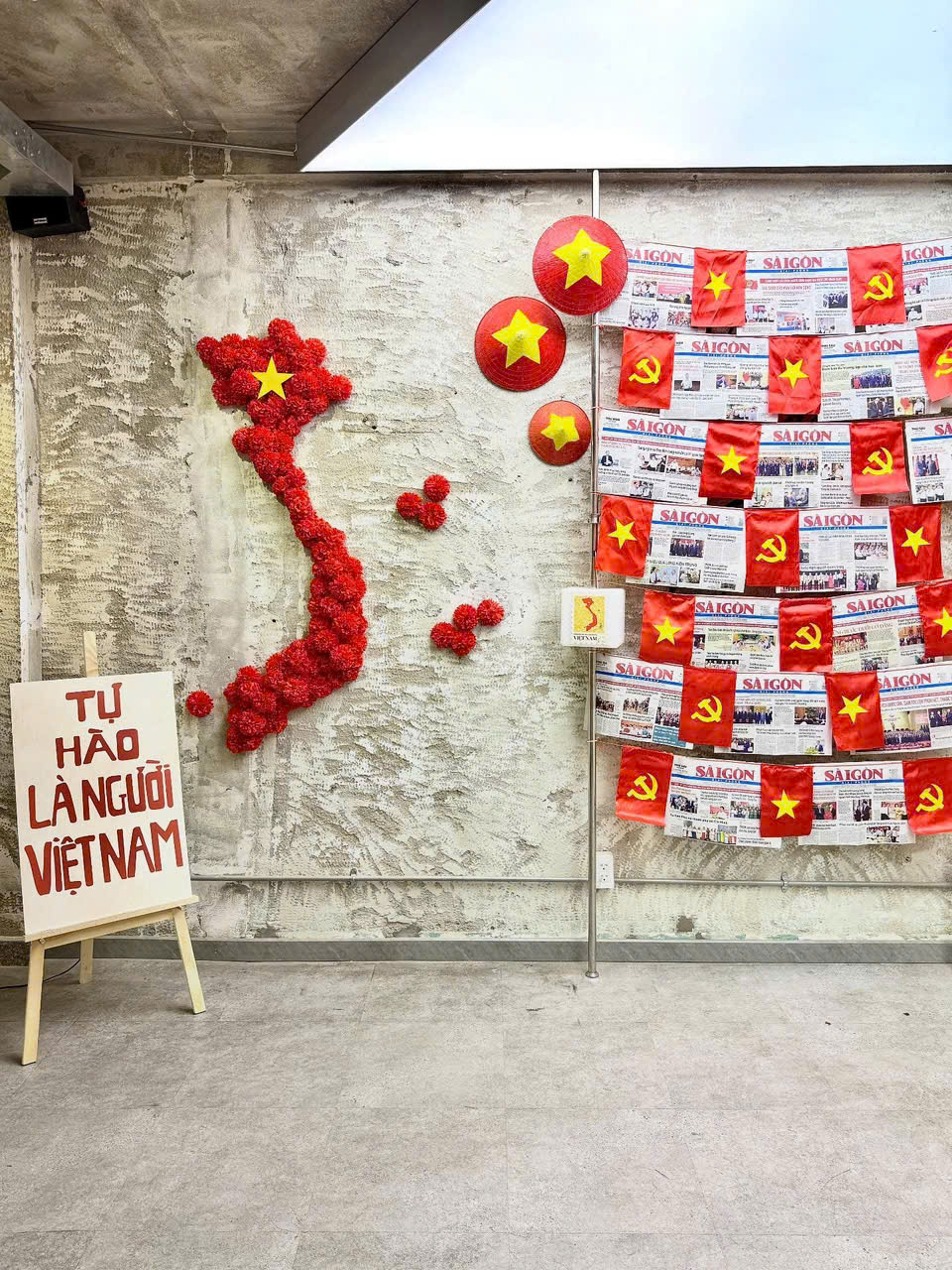 Bên trong quán cũng có nhiều góc check-in hấp dẫn, đặc biệt phải là góc với bản đồ Việt Nam được xếp từ những bông hoa giấy, bên cạnh là những tờ báo cũ cùng những chiếc nón lá mang sắc đỏ đặc trưng. Tại đây, mỗi khung hình không chỉ là một bức ảnh “sống ảo” mà còn là một lát cắt ký ức, nơi khách ghé thăm có thể cảm nhận rõ hơn tinh thần của ngày thống nhất, được tái hiện qua lăng kính sáng tạo và đầy cảm xúc của quán.