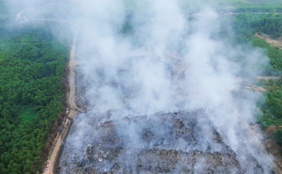 Bãi rác cháy âm ỉ kéo dài khiến khói nghi ngút bao phủ cả vùng rộng lớn - Ảnh: Khánh Trung