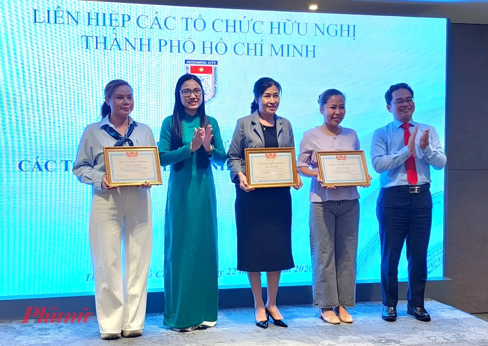Bà Hà Thanh (thứ 2 từ trái sang) và ông Phạm Minh Tuấn - Phó Chủ tịch Ủy ban Mặt trận Tổ quốc Việt Nam TPHCM (bìa phải) trao tặng giấy khen cho các tổ chức phi chính phủ có hoạt động xuất sắc trong thời gian qua