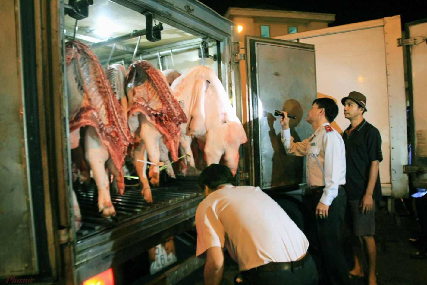 Cán bộ Sở An toàn thực phẩm TPHCM kiểm tra nguồn thịt heo được chở về chợ đầu mối Bình Điền - ẢNH: QUỐC THÁI