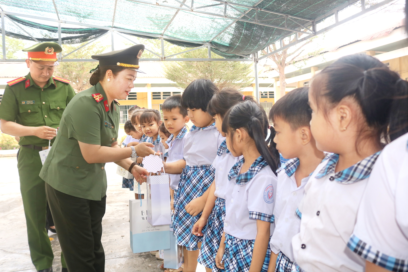 Thượng tá Đào Thị Thu Huyền - Phó trưởng ban Phụ nữ Công an nhân dân - trao quà cho các em học sinh Trường tiểu học Tiên Thuận B