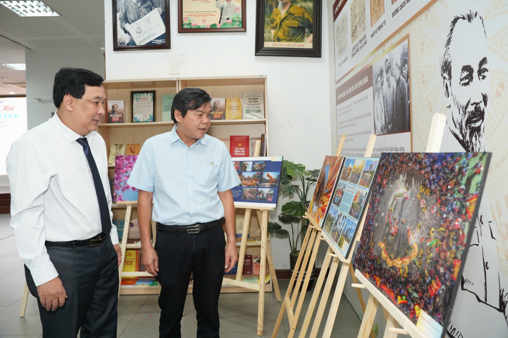 Ông Tăng Hữu Phong - Phó Trưởng ban Tuyên giáo và Dân vận Thành ủy TPHCM (bìa phải) và  nhà báo Nguyễn Thái Bình - Phó Tổng Biên tập Báo Pháp Luật TPHCM tham quan khu vực triễn lãm ảnh. Ảnh: BTC