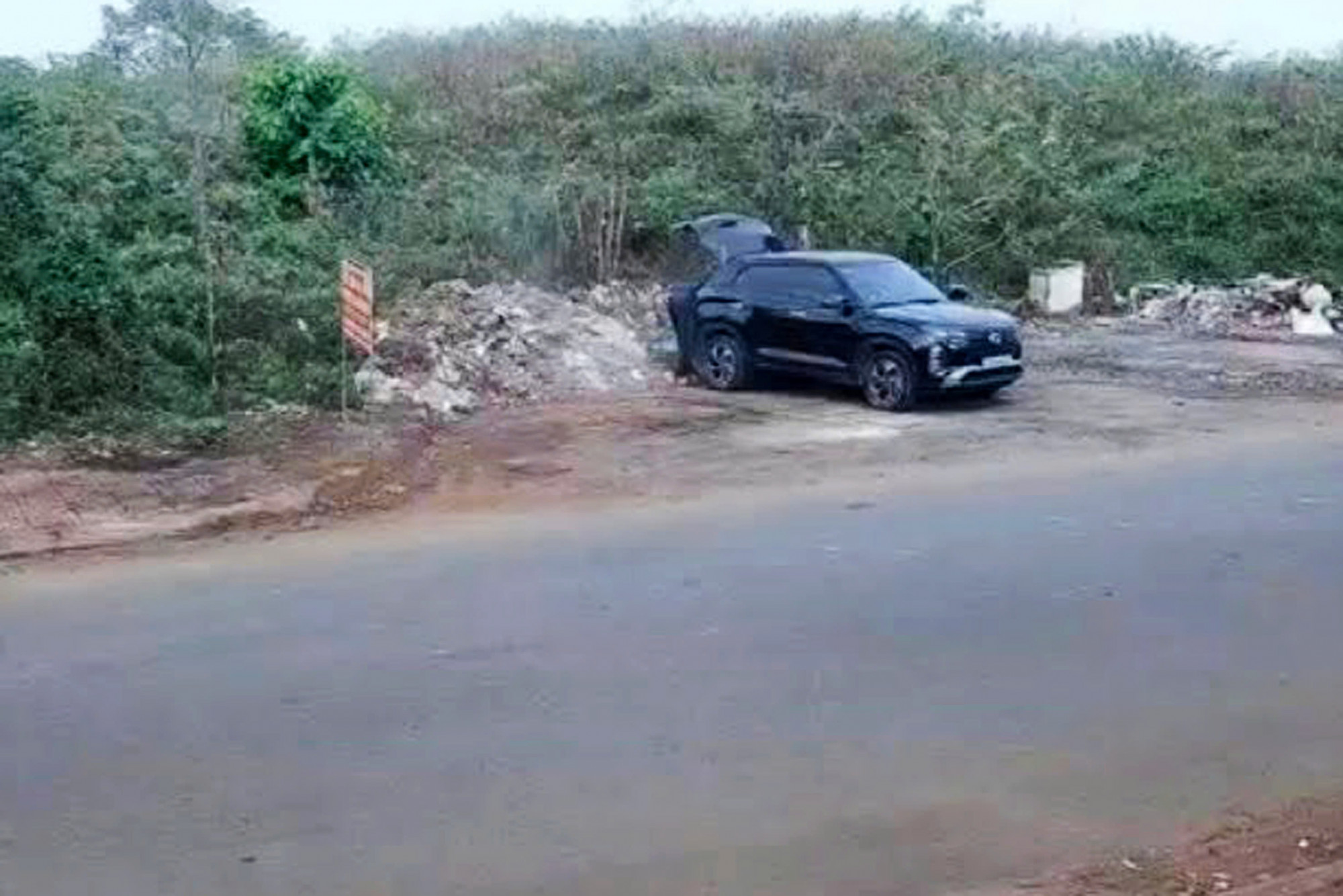 Người đàn ông dùng xe ô tô chở rác đi vứt không đúng nơi quy định - ảnh: C.N.