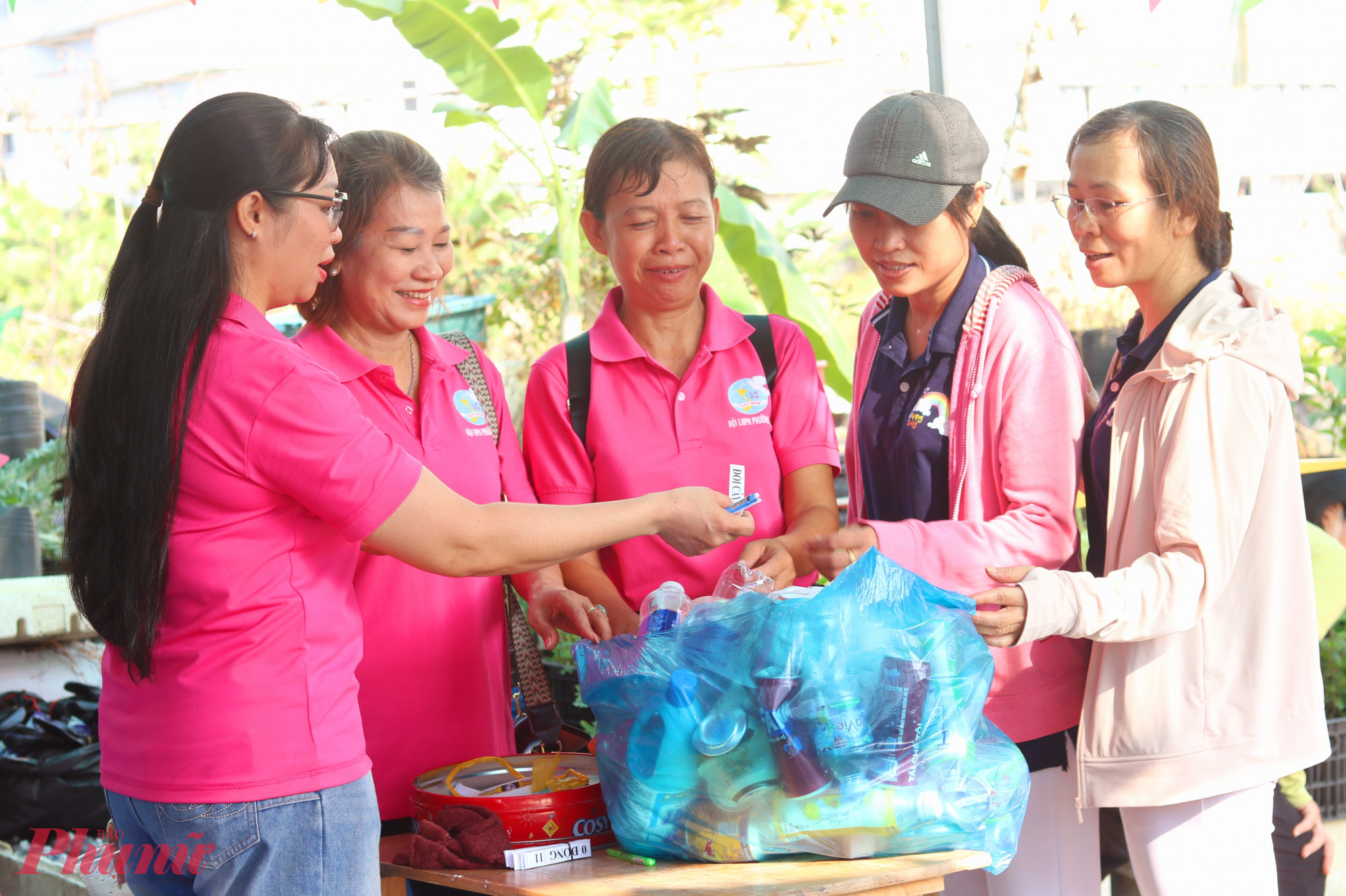 Chị em mang rác thải nhựa tới vườn để đổi lấy cây con - Ảnh: Thảo Nguyên