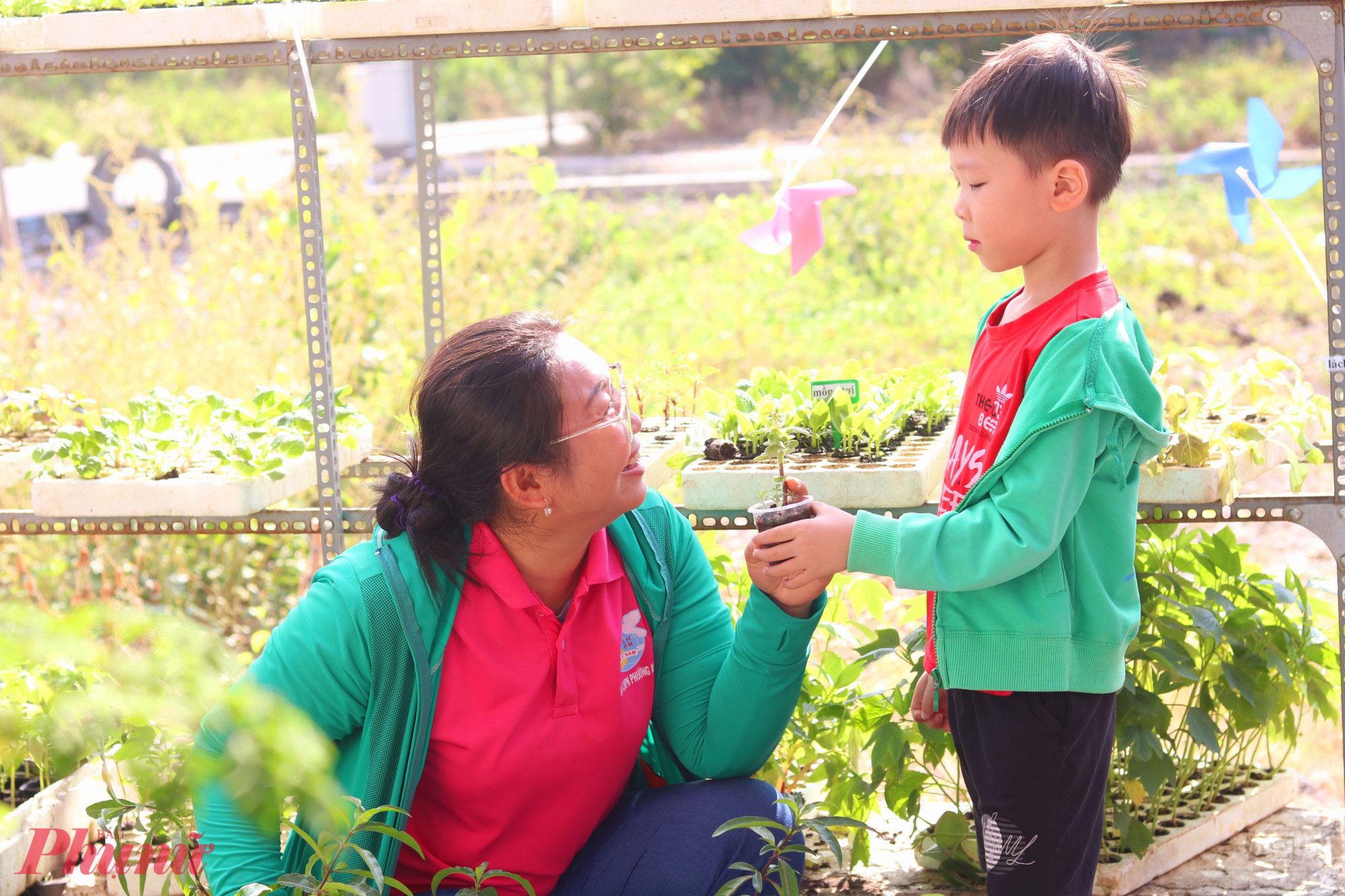 Cậu bé Trần Ngọc Huy Long theo mẹ đến vườn chọn cây con - Ảnh: Thảo Nguyên