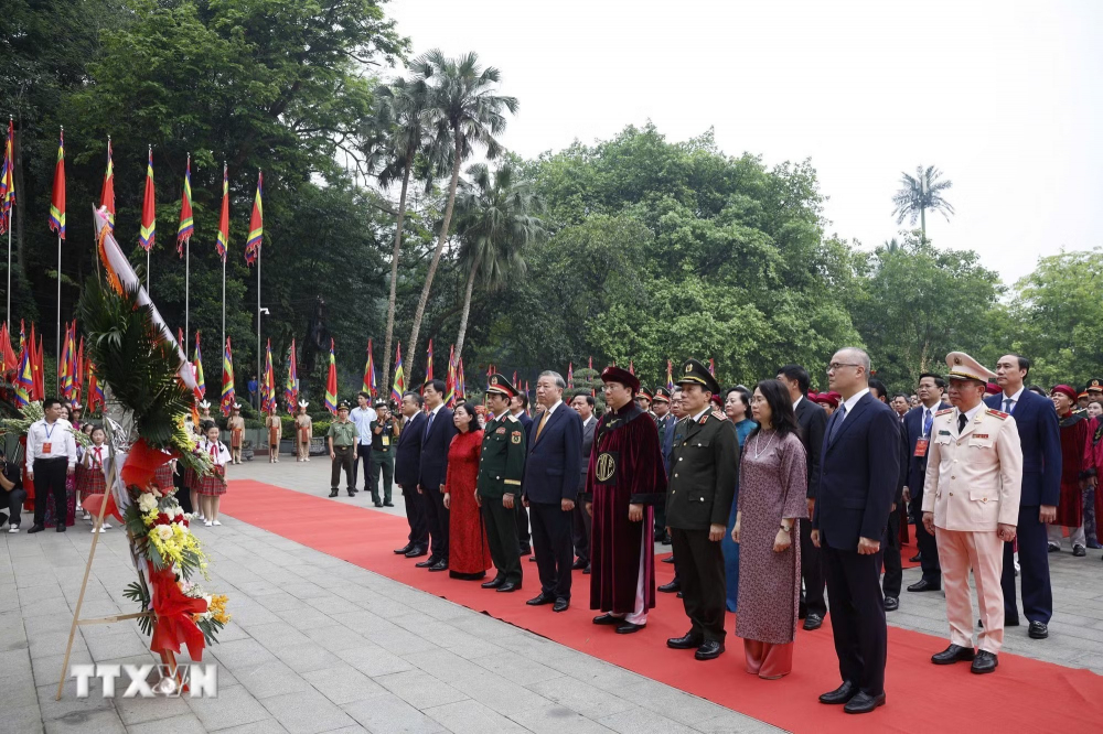 Tổng bí thư, Chủ tịch nước Tô Lâm và các đại biểu dâng hoa tại Bức phù điêu Bác Hồ nói chuyện với cán bộ, chiến sĩ Đại đoàn quân Tiên Phong - Ảnh: Thống Nhất/TTXVN