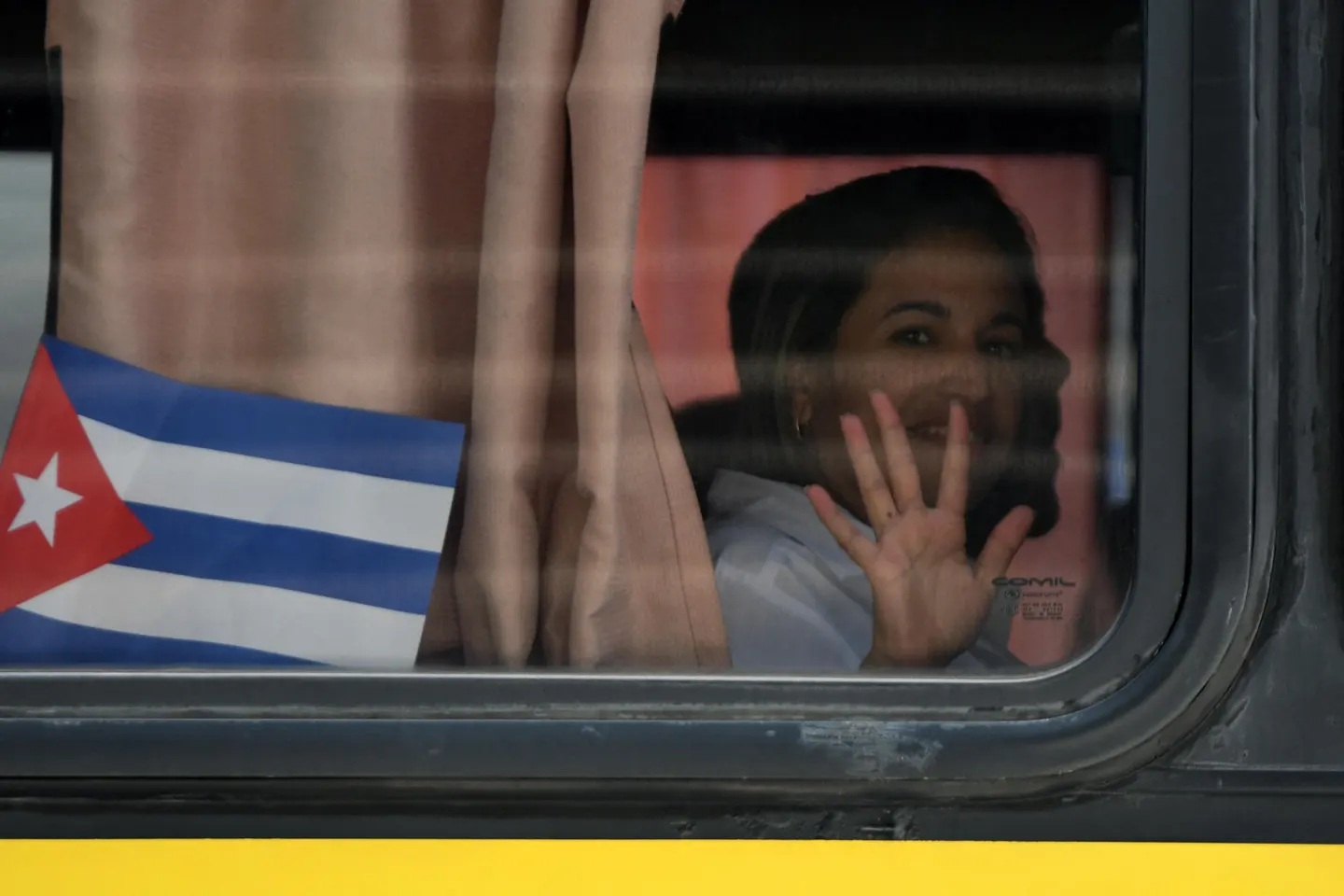 Một bác sĩ người Cuba vẫy tay từ trong xe buýt khi đến Sân bay Quốc tế Palmerola, Honduras vào tháng 2/2024 - Ảnh: Orlando Sierra/Getty Images