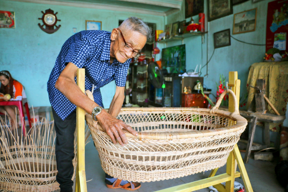 Ông Trần Văn Thành đang kiểm tra nôi mây đã hoàn thiện trước khi giao cho khách - ẢNH: NGỌC MINH