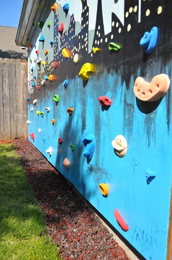 Nếu bạn có một bức tường trống cao, hãy biến nó thành một bức tường leo núi trong sân sau. Bạn có thể làm điều đó với ván gỗ đã được xử lý cường lực, ốc vít chắc chắn và đính nhiều tay nắm leo núi. Nguồn ảnh: impatientlycrafty.com. 