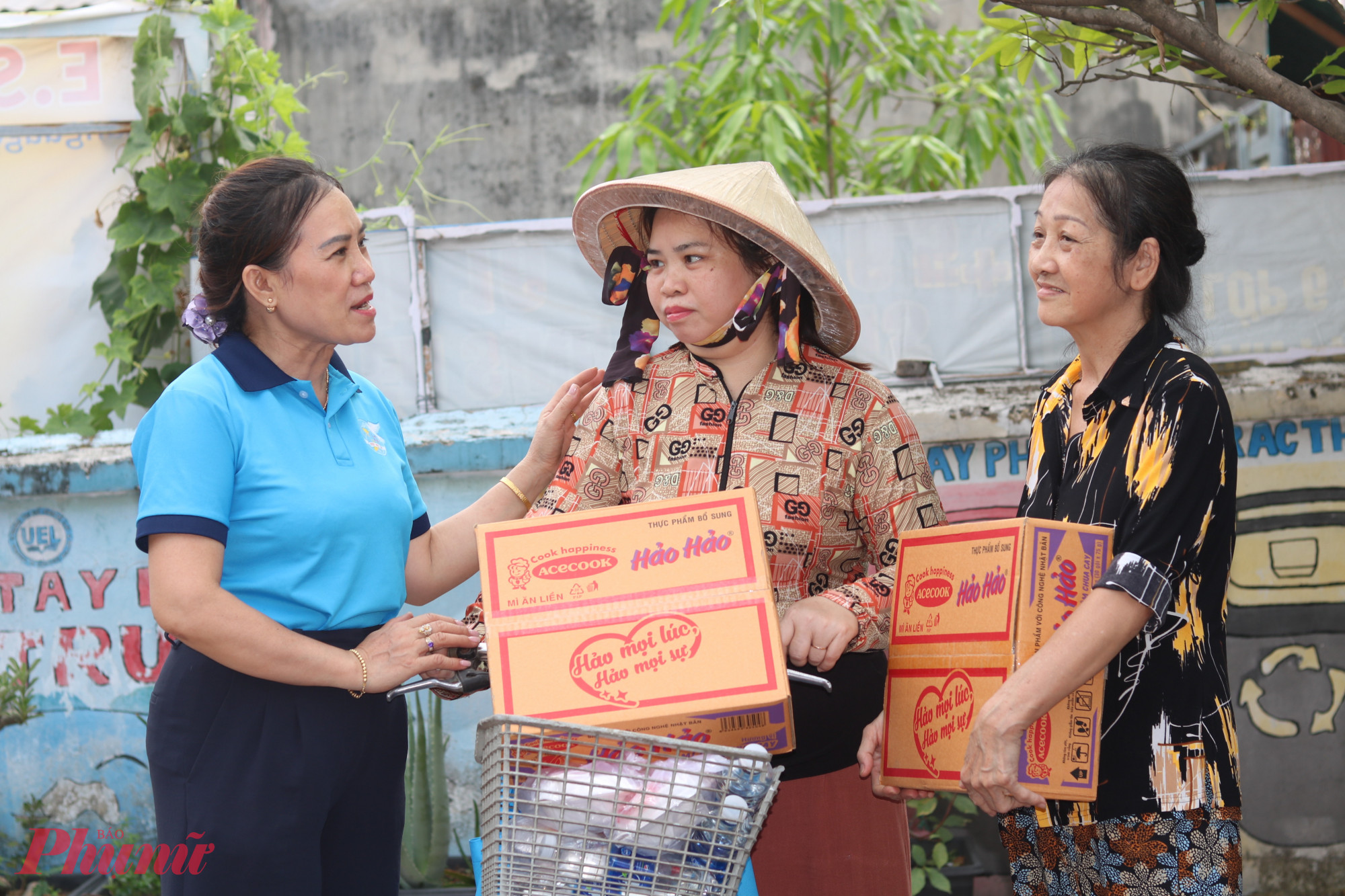 Chị Nguyễn Thị Hồng Vân – Chi hội trưởng Chi hội Phụ nữ khu phố 38, phường Tân Thới Hiệp (bìa trái) – trò chuyện, động viên chị em được hỗ trợ thực phẩm thiết yếu - Ảnh: Thảo Nguyên