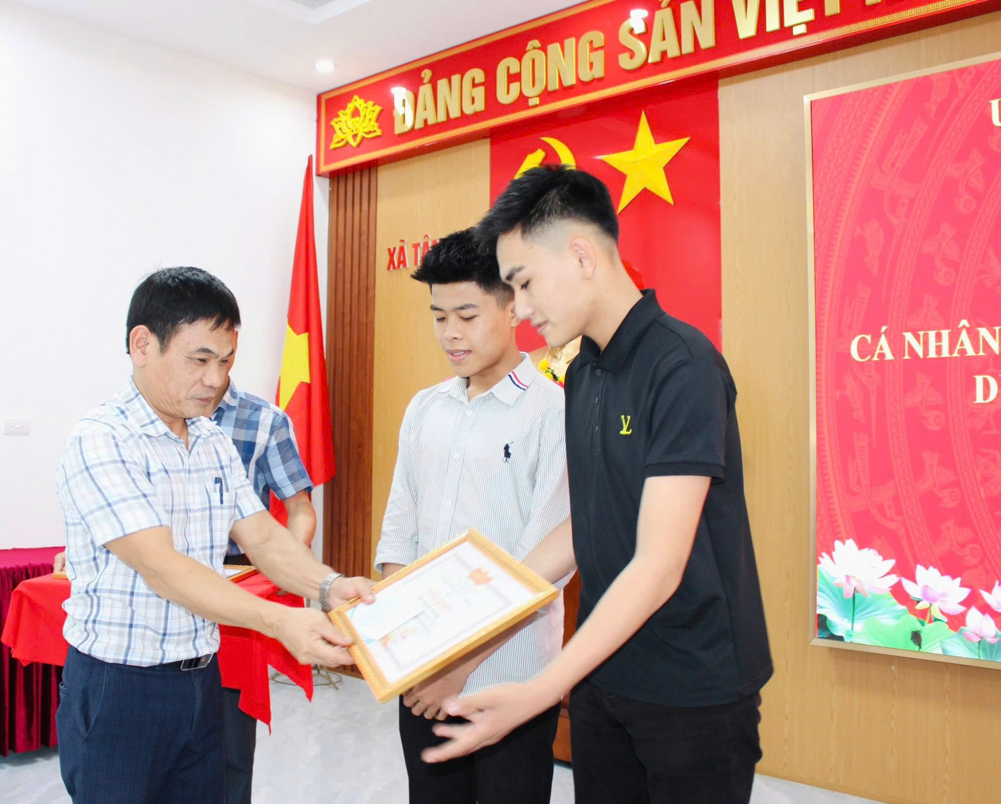 Lãnh đạo xã Tân An tặng giấy khen cho 2 nam sinh - Ảnh: Khánh Trung