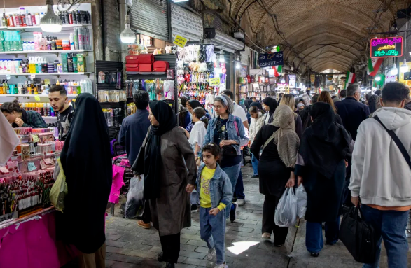 Mọi người lướt qua các quầy hàng tại Tehran Grand Bazaar sau khi giá cả tăng do lạm phát gây ra bởi cuộc xung đột, vào ngày 16 tháng 4. Majid Saeedi / Getty Images