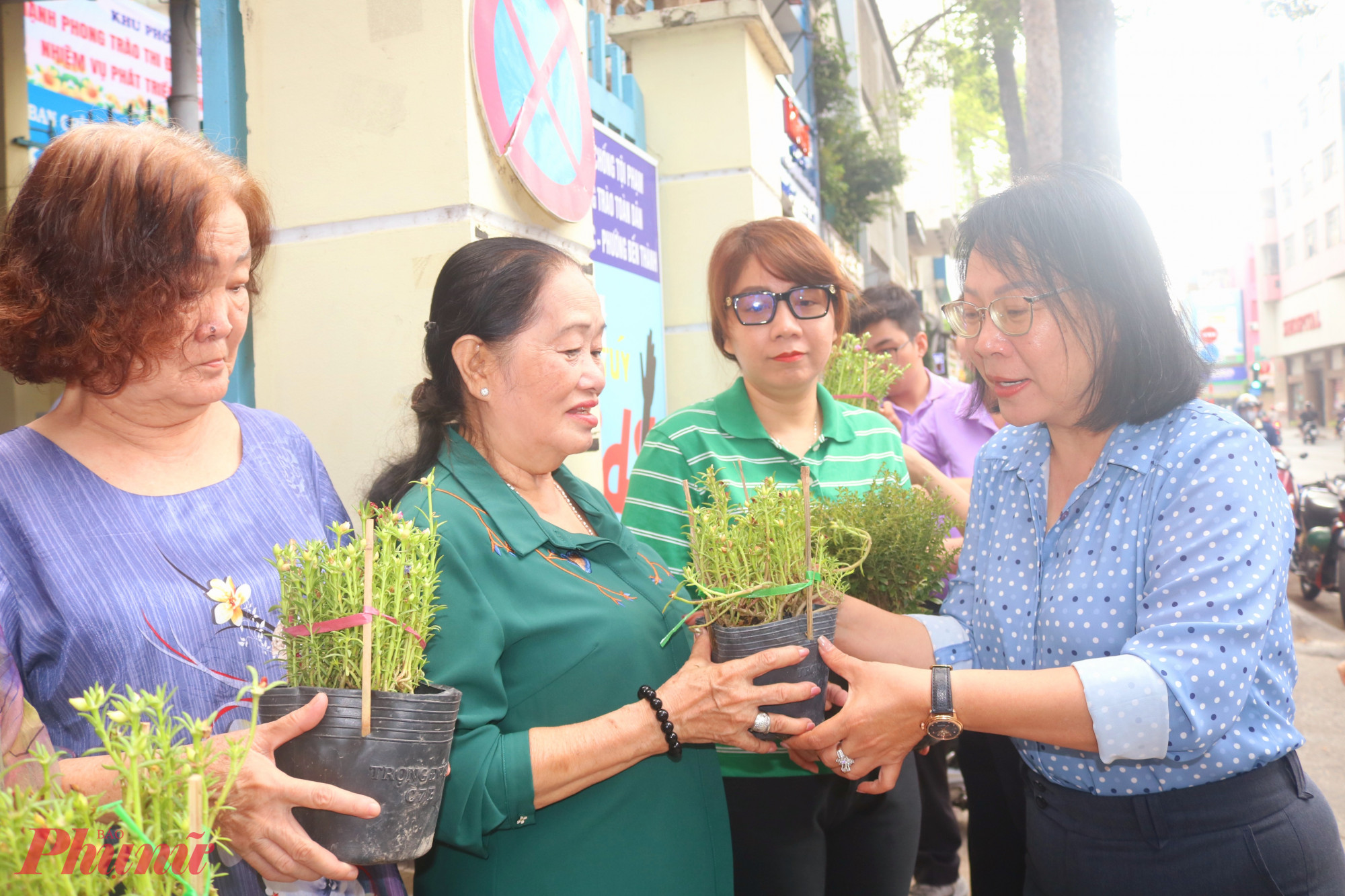 Bà Phạm Thị Ngọc Minh – Chủ tịch Ủy ban MTTQ Việt Nam phường Bến Thành – tặng chậu hoa đến đại diện các hộ dân - Ảnh: Thảo Nguyên