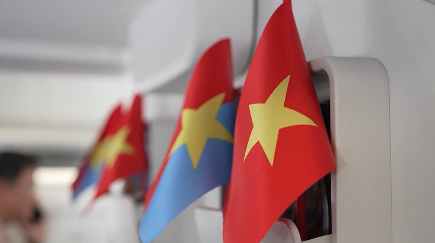 2. Những lá cờ Tổ quốc được gửi tới tận tay hành khách, được phất cao cùng những giai điệu tự hào đã mang đến những cảm xúc đặc biệt. Ảnh: VNA