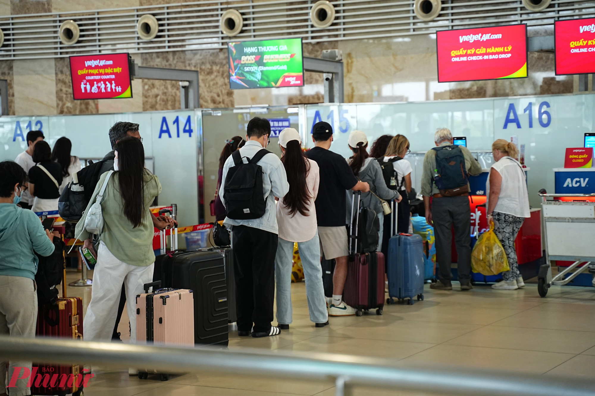 Hành khách xếp hàng dài chờ làm thủ tục lên máy bay.