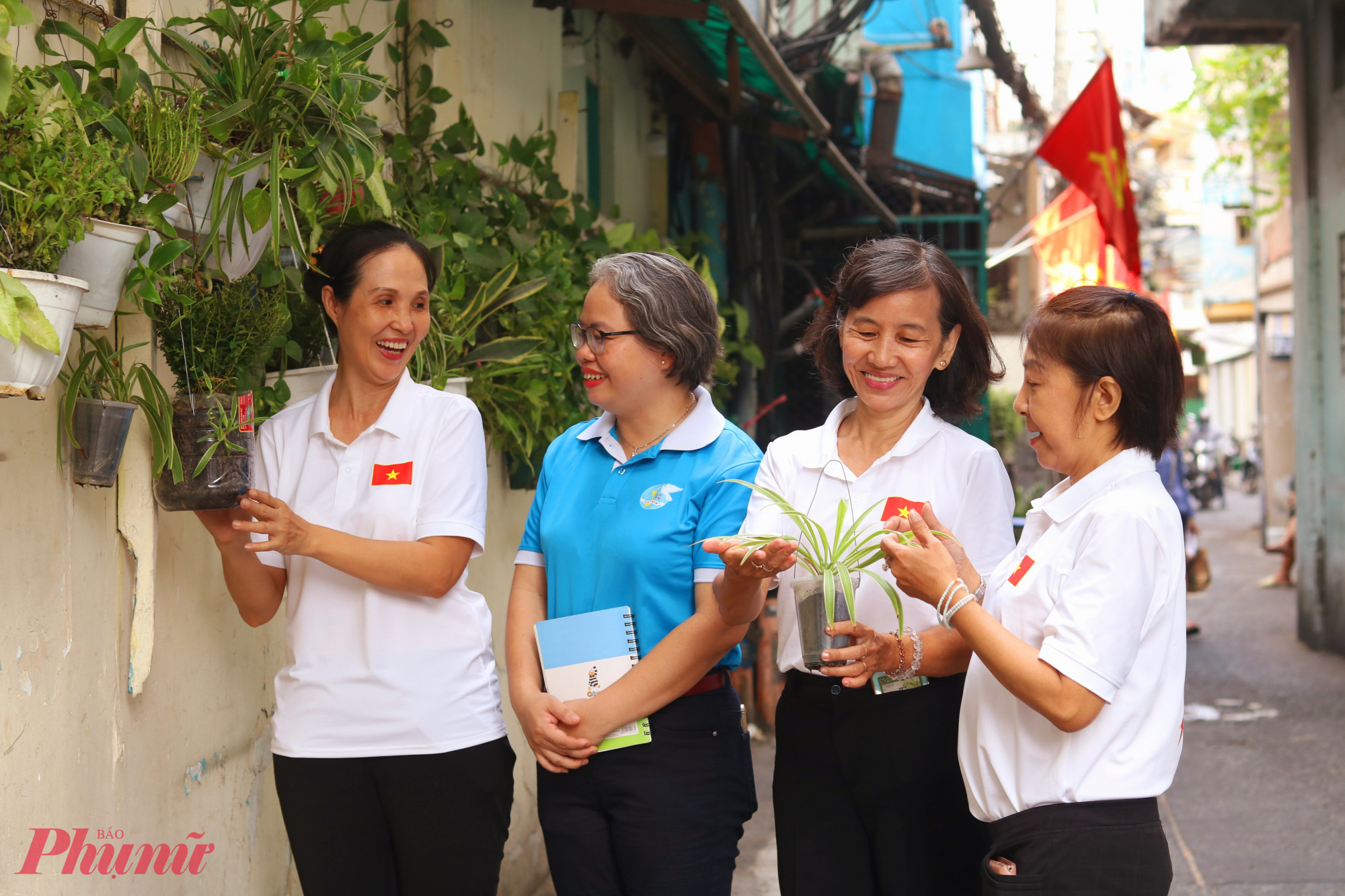 Bà Nguyễn Thị Hồng Nhung – Phó chủ tịch Ủy ban MTTQ Việt Nam phường Bến Thành, Chủ tịch Hội LHPN phường (thứ 2, từ trái qua) – động viên các dì, các chị nỗ lực chăm sóc, giữ gìn góc xanh trong hẻm 134 Bùi Thị Xuân - Ảnh: Thảo Nguyên 