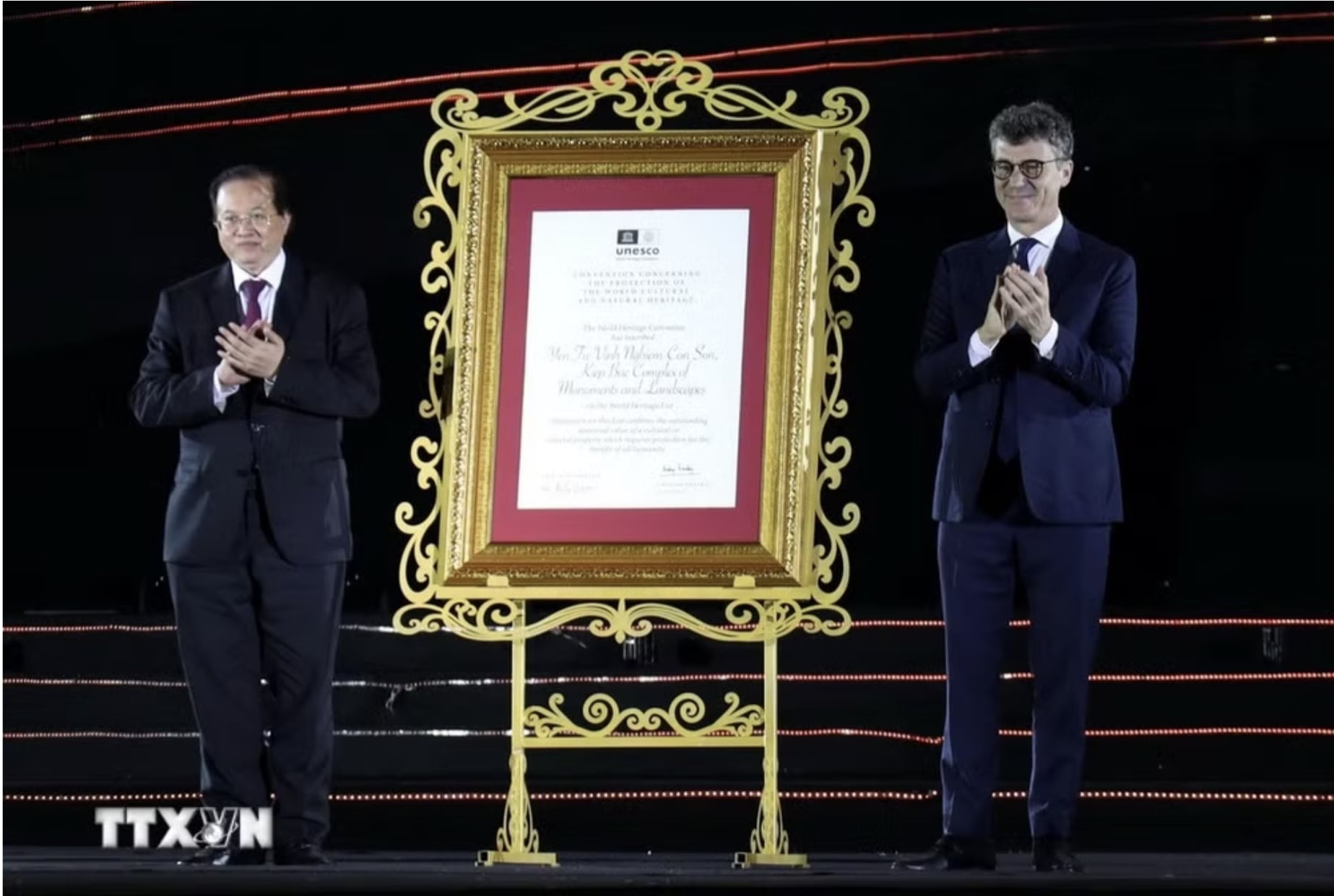 Ông Jonathan Baker, Trưởng Đại diện UNESCO tại Việt Nam (bên phải) trao Bằng UNESCO ghi danh Quần thể Di tích và Danh thắng Yên Tử - Vĩnh Nghiêm - Côn Sơn, Kiếp Bạc là Di sản văn hóa thế giới cho ông Tạ Quang Đông, Thứ trưởng Bộ Văn hóa, Thể thao và Du lịch. (Ảnh: Đức Hiếu/TTXVN)