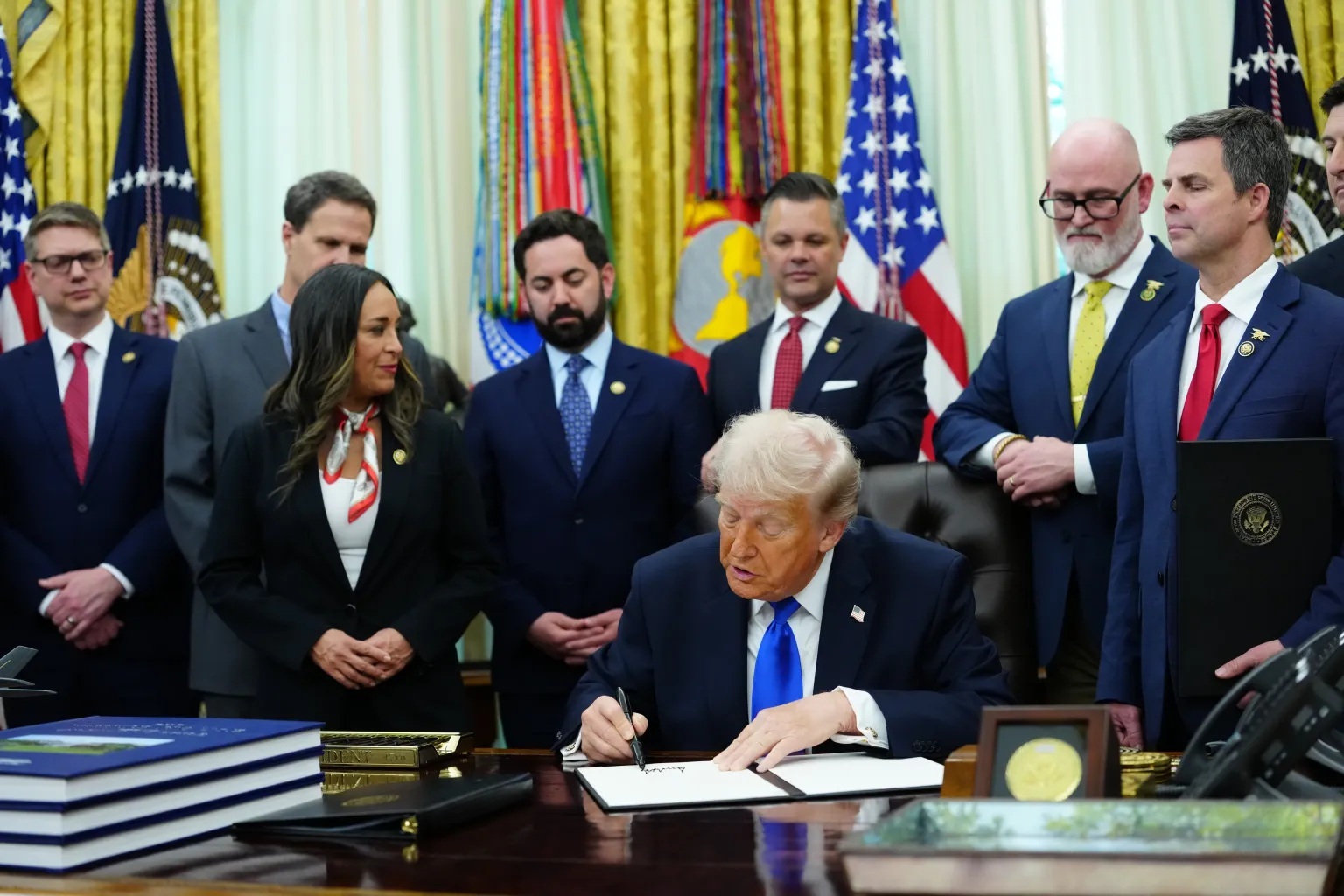 Tổng thống Donald Trump ký các sắc lệnh hành pháp tại Nhà Trắng trong khi trả lời câu hỏi từ giới truyền thông - Ảnh: Shutterstock