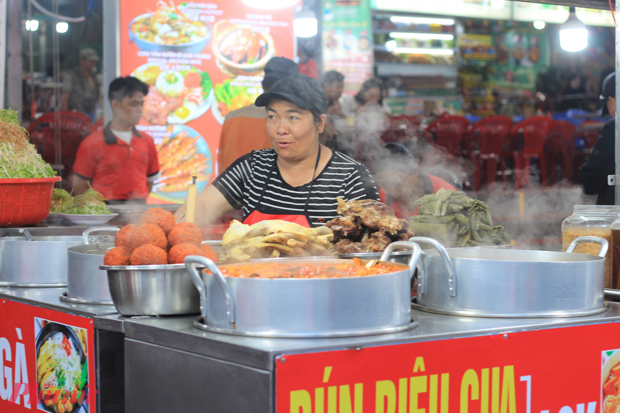 Nếu muốn ăn chắc bụng hơn, khu ẩm thực bên trong chợ lại mở ra thêm một thế giới khác với xôi nóng, bún bò, bún riêu, bánh căn, súp và đủ món xiên nướng. Những nồi nước dùng nghi ngút khói, khuôn bánh nóng rẫy hay tiếng lách tách từ bếp than khiến bụng đang no cũng dễ thấy thèm.