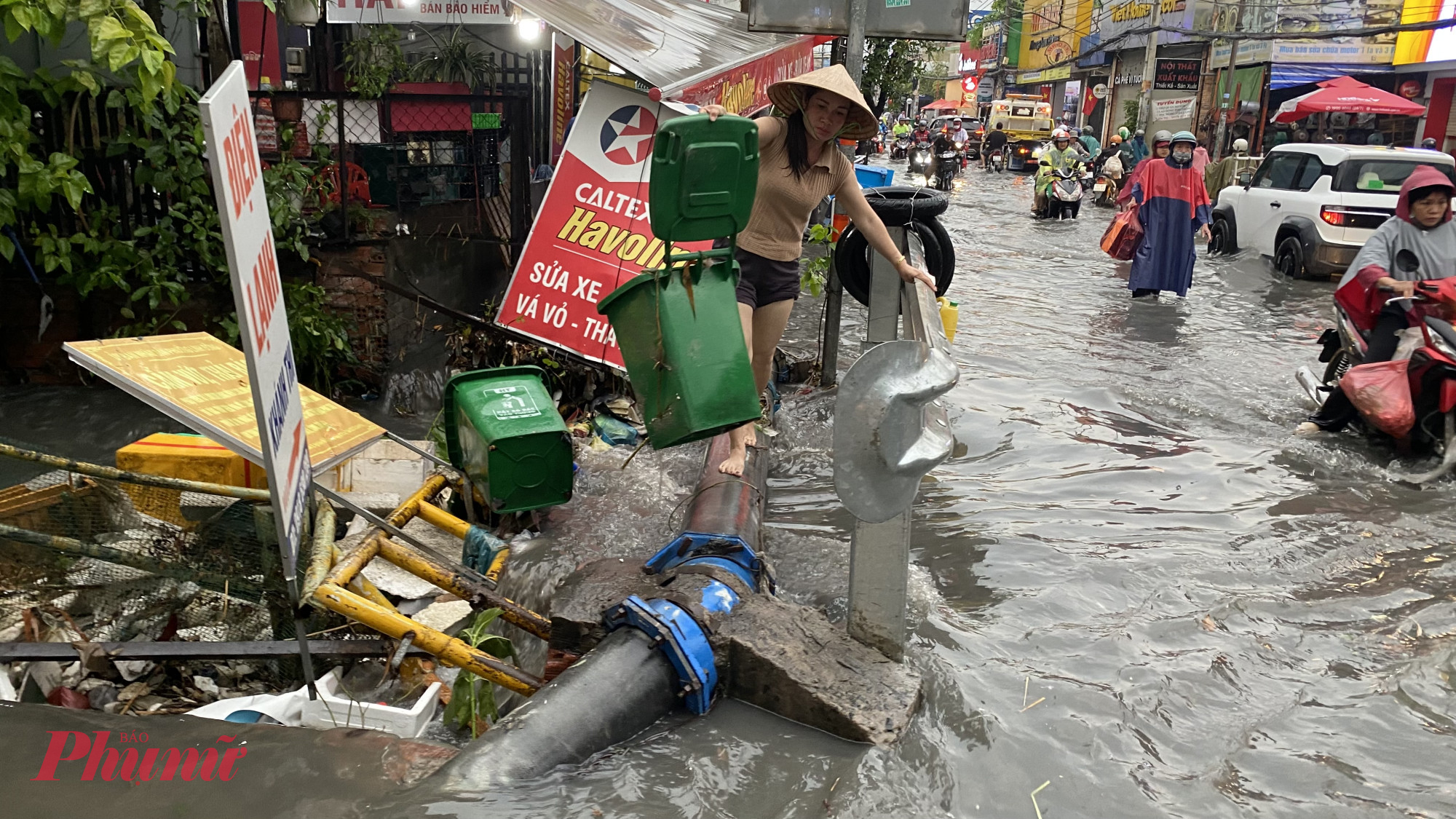 Người dân dọn thu dọn vật dụng và rác thải bị nước cuốn trôi mắc kẹt tại suối Linh Đông trên đường Tô Ngọc Vân
