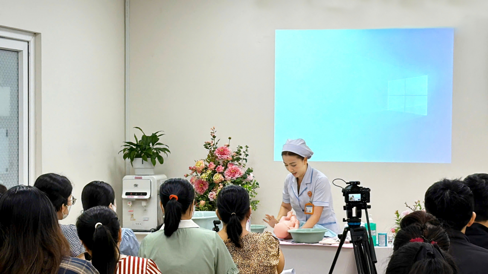 Thạc sĩ, điều dưỡng  Nguyễn Vũ Phương Quỳnh  - giảng viên lớp tiền sản,  Bệnh viện Hùng Vương, TPHCM  - hướng dẫn các cặp vợ chồng cách tắm cho bé sơ sinh  - ẢNH: THANH HUYỀN