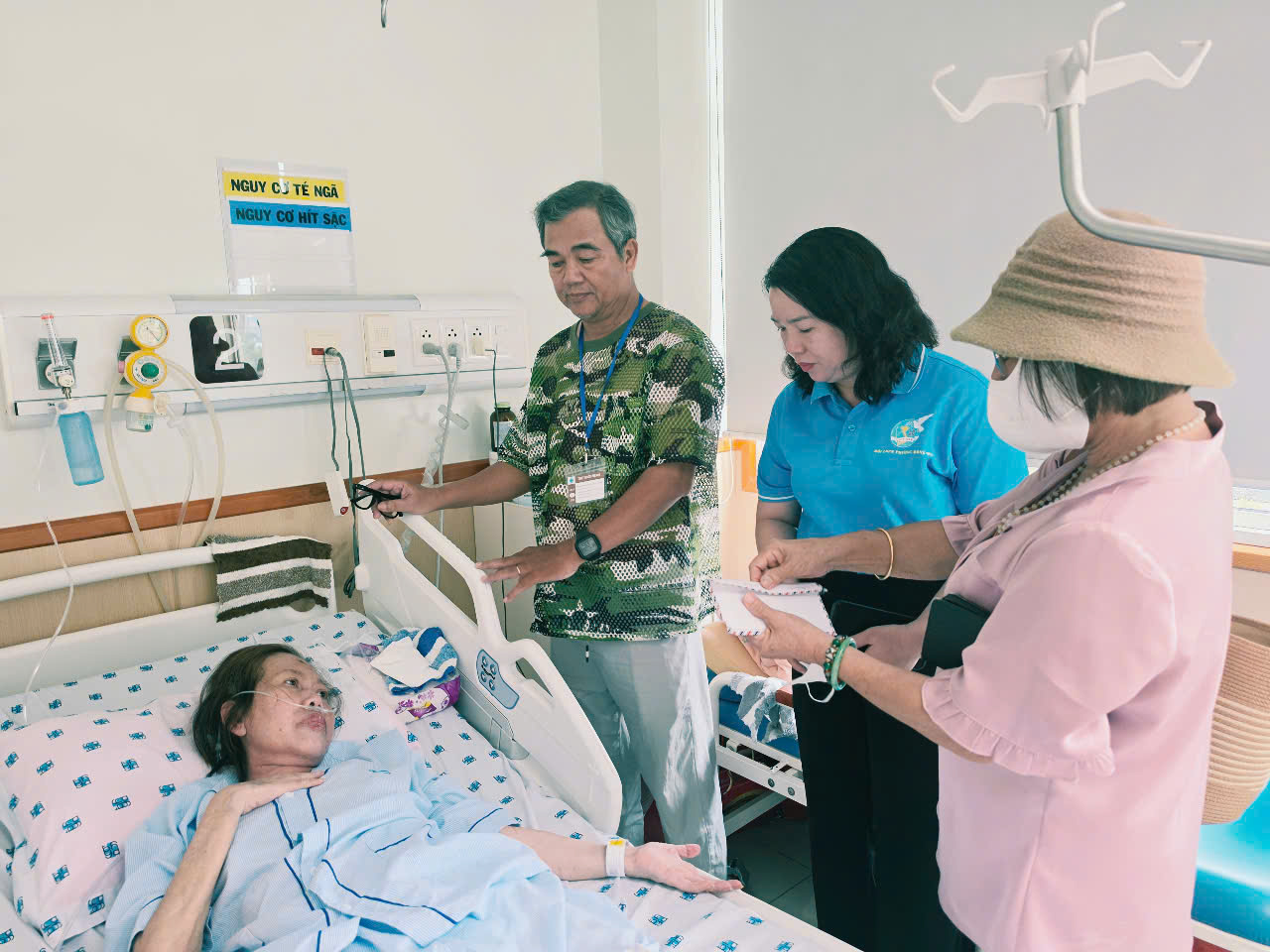 Hội LHPN phường Đông Hòa và bà Phạm Thị Xuân Mai - đại diện Nhóm Từ thiện Dĩ An - trao số tiền 20 triệu đồng, tiếp sức giúp chị Điệp điểu trị bệnh tình 