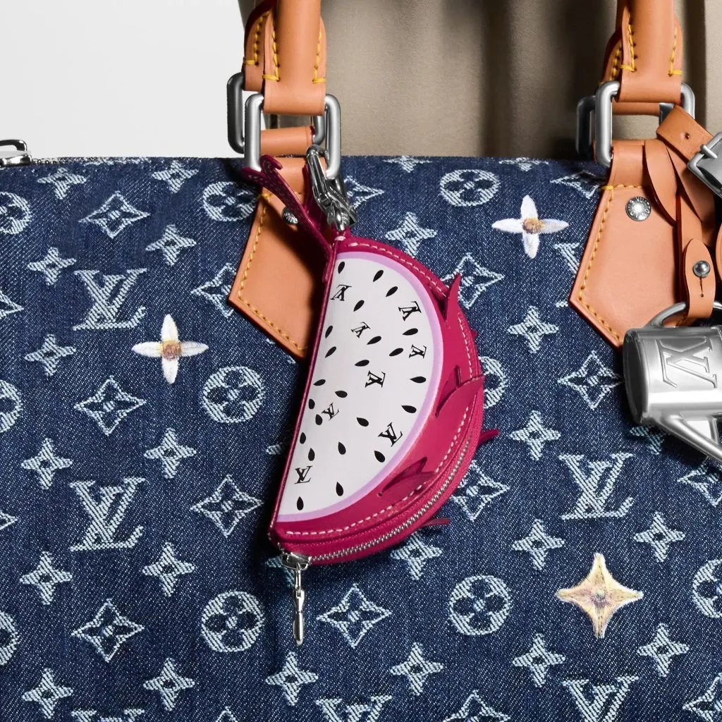Móc khóa túi hình trái thanh long của Louis Vuitton. Được chế tác từ da, nó thể hiện trái thanh long một cách thú vị với vỏ màu hồng tươi và hạt màu đen. Móc khóa LV này đủ lớn để đựng chìa khóa và tai nghe không dây - Ảnh: Louis Vuitton