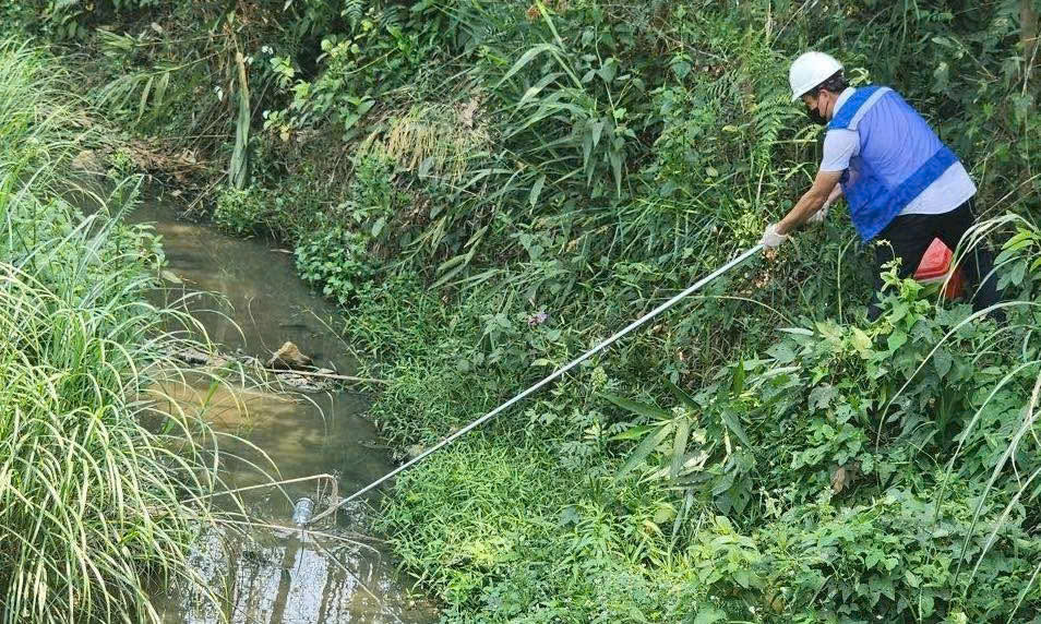 Cơ quan chức năng lấy mẫu nước tại khu vực khe Rào Trường để kiểm tra dấu hiệu ô nhiễm liên quan đến hoạt động của trang trại chăn nuôi lợn ở xã Bến Quan, tỉnh Quảng Trị.