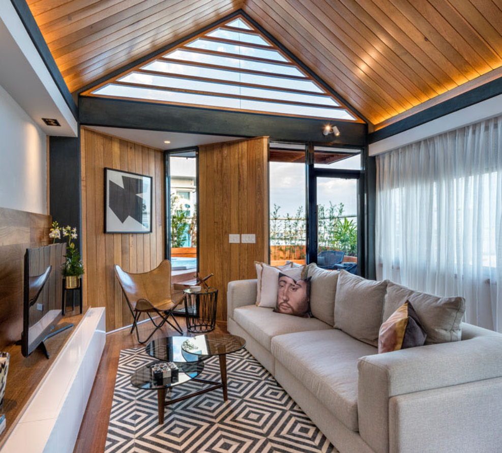 Một gian bếp nhỏ và quầy bar giúp việc tiếp khách trở nên dễ dàng, trong khi chiếc ghế sofa lớn rất lý tưởng cho những buổi tối xem phim cùng gia đình hoặc những buổi tối thư giãn bên nhau. Ảnh: @Narquitectura/ Laurelen González. 